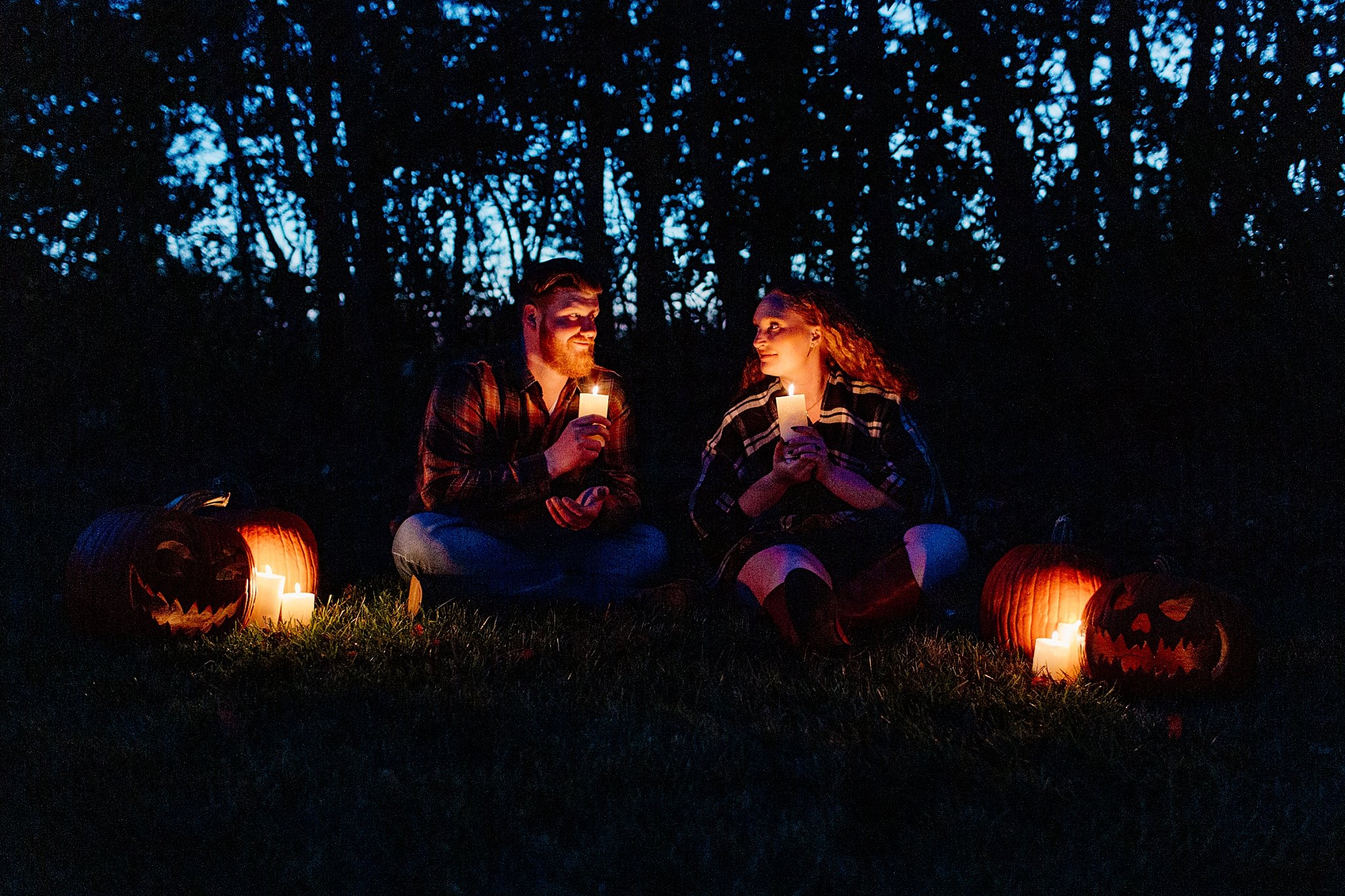  Candles light faces of two people at Halloween engagement session 
