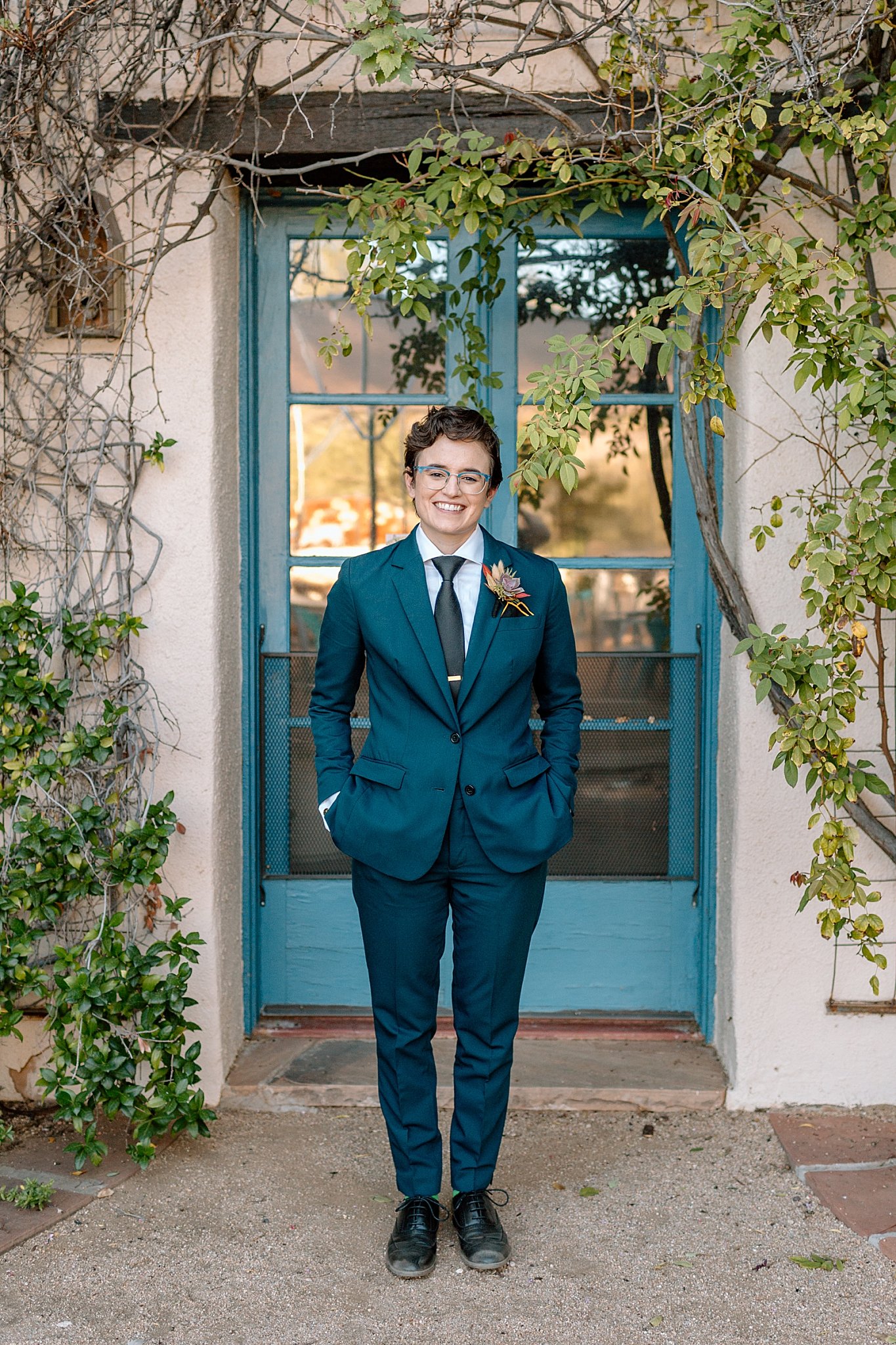  woman stands in front of blue door at Tucson botanical gardens ceremony 