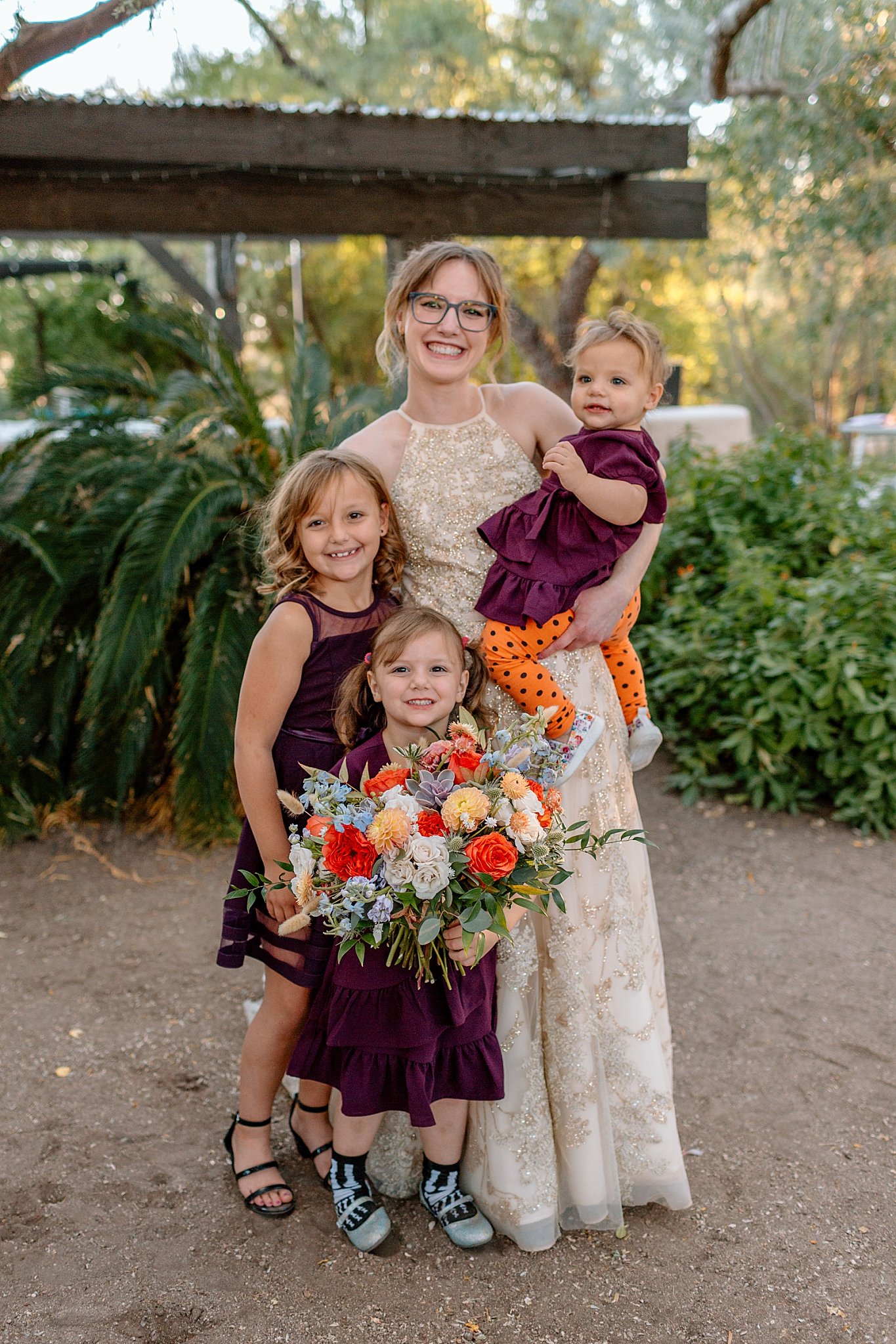  children stand with bride by Arizona wedding photographer 