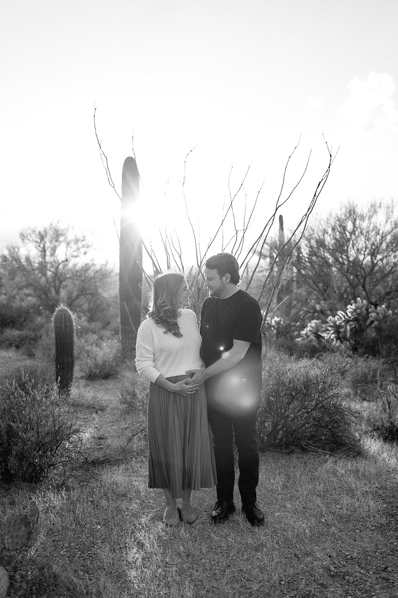  parents to be look at each other while holding growing belly by Arizona Couples Photographer 
