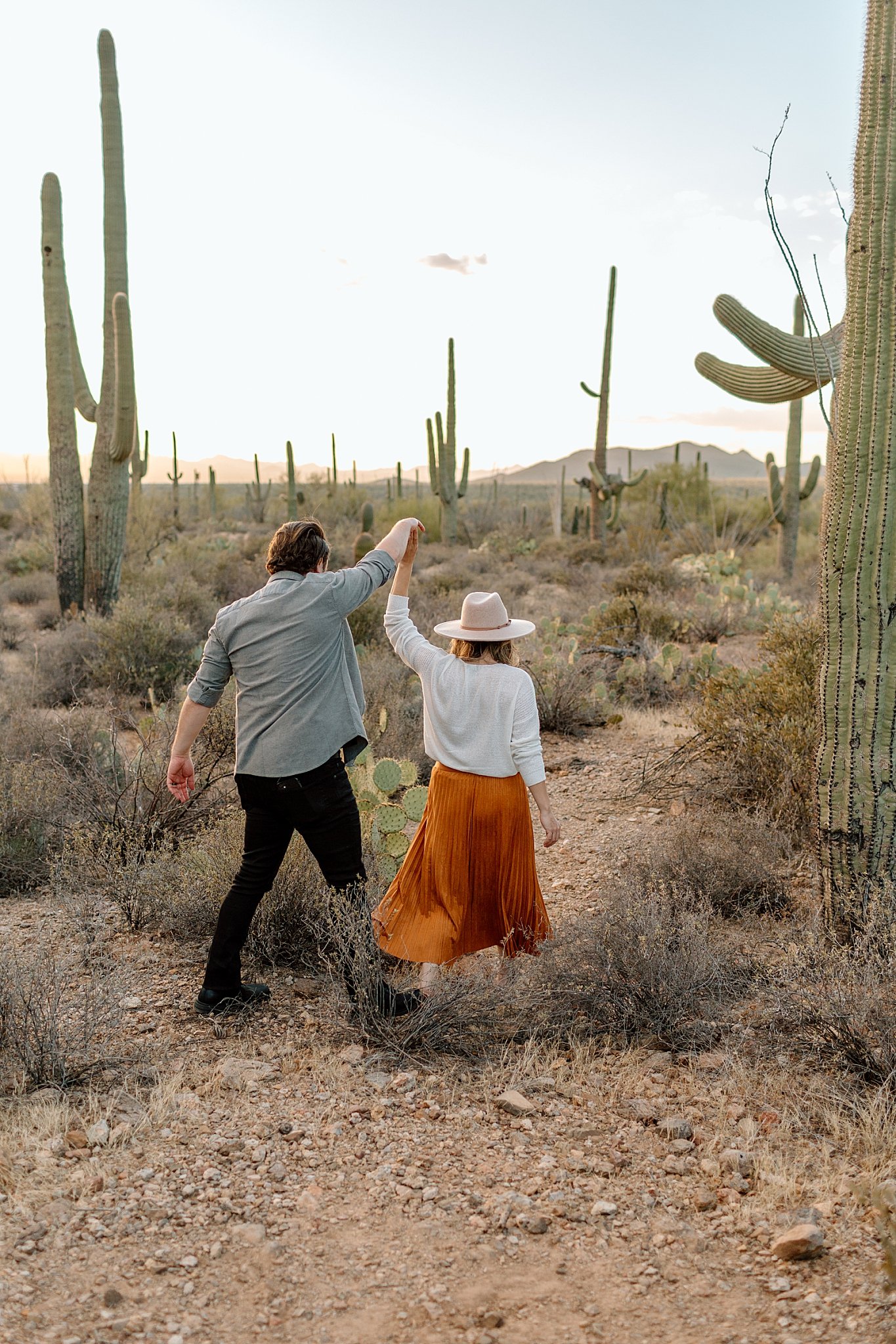  couple holds hands walking in desert by Arizona Couples Photographer 