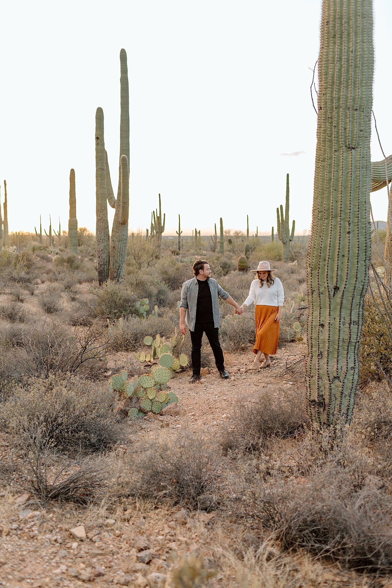 man and woman walk together holding hands in desert by Lucy B Photography 