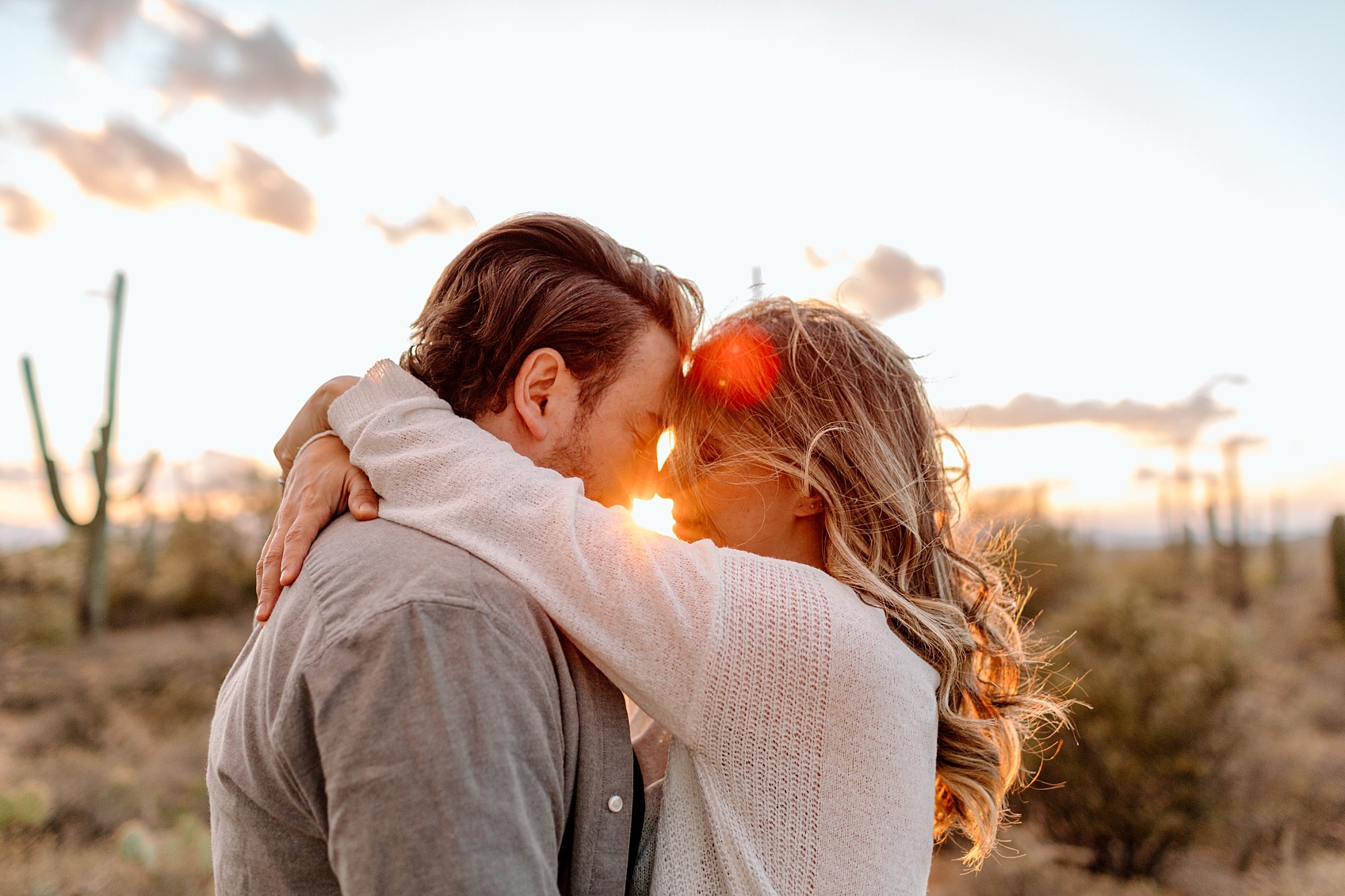  woman wraps arms around man’s neck as sun shines by Lucy B Photography 