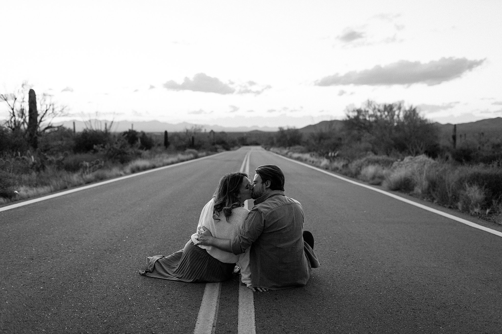  couple kisses sitting in road at sunset for Arizona Couples Photographer 