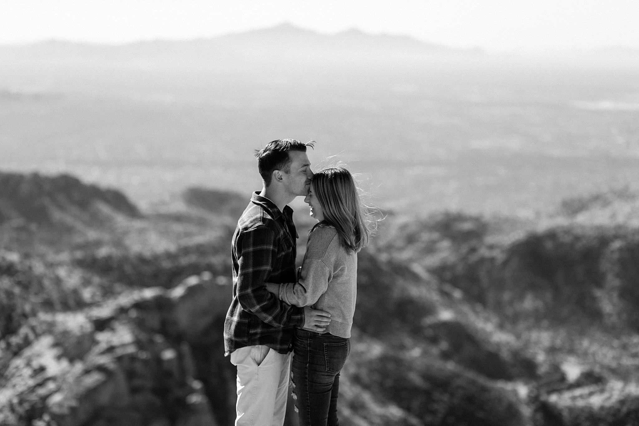  man kisses woman on forehead by Arizona engagement photographer 