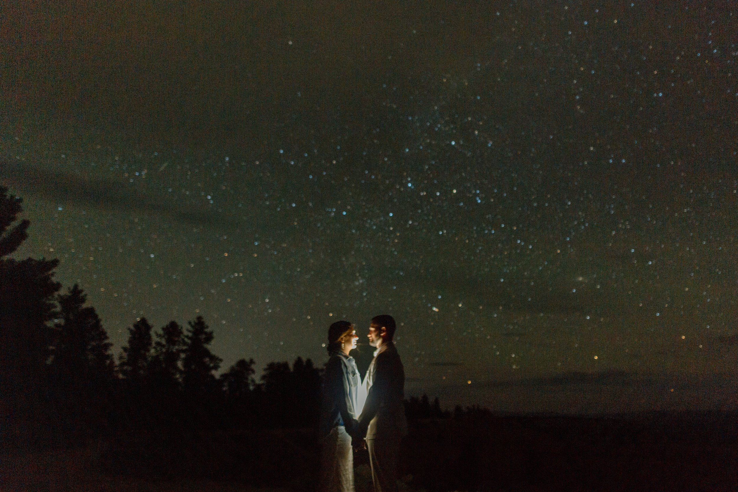  elopement couple hold hands while lit from behind with stars in the background by utah elopement photographer 