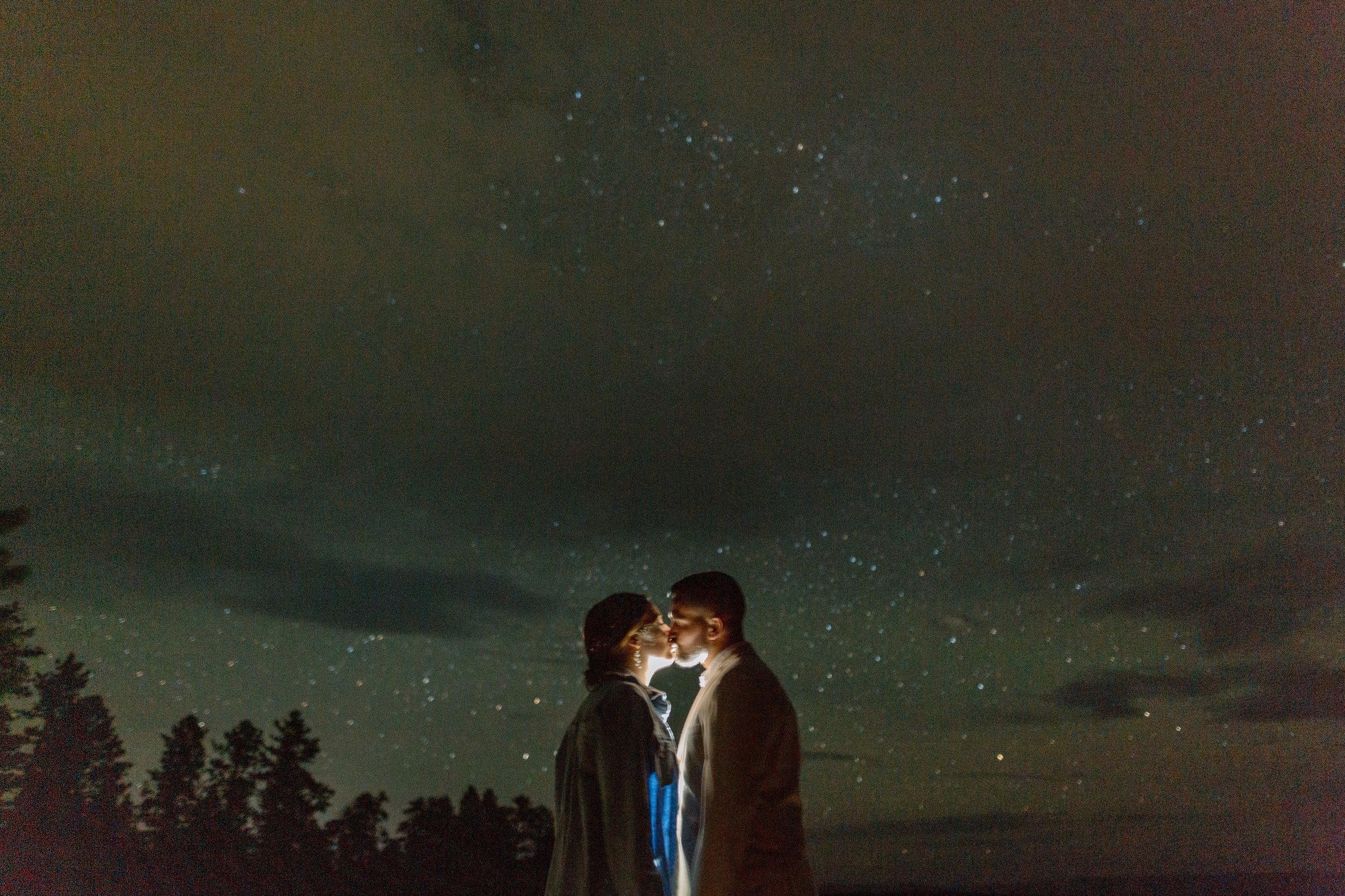  utah elopement couple kisses in front of night stars while lit from behind during bryce canyon elopement 