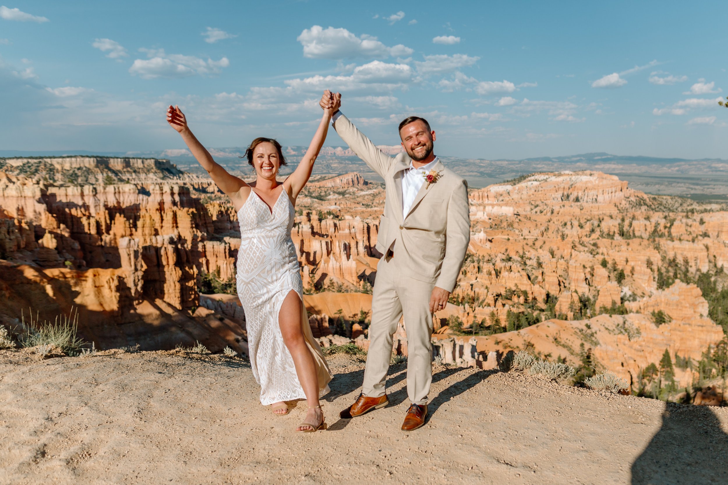  couple lifts hands in celebration after their elopement ceremony at bryce canyon national park 