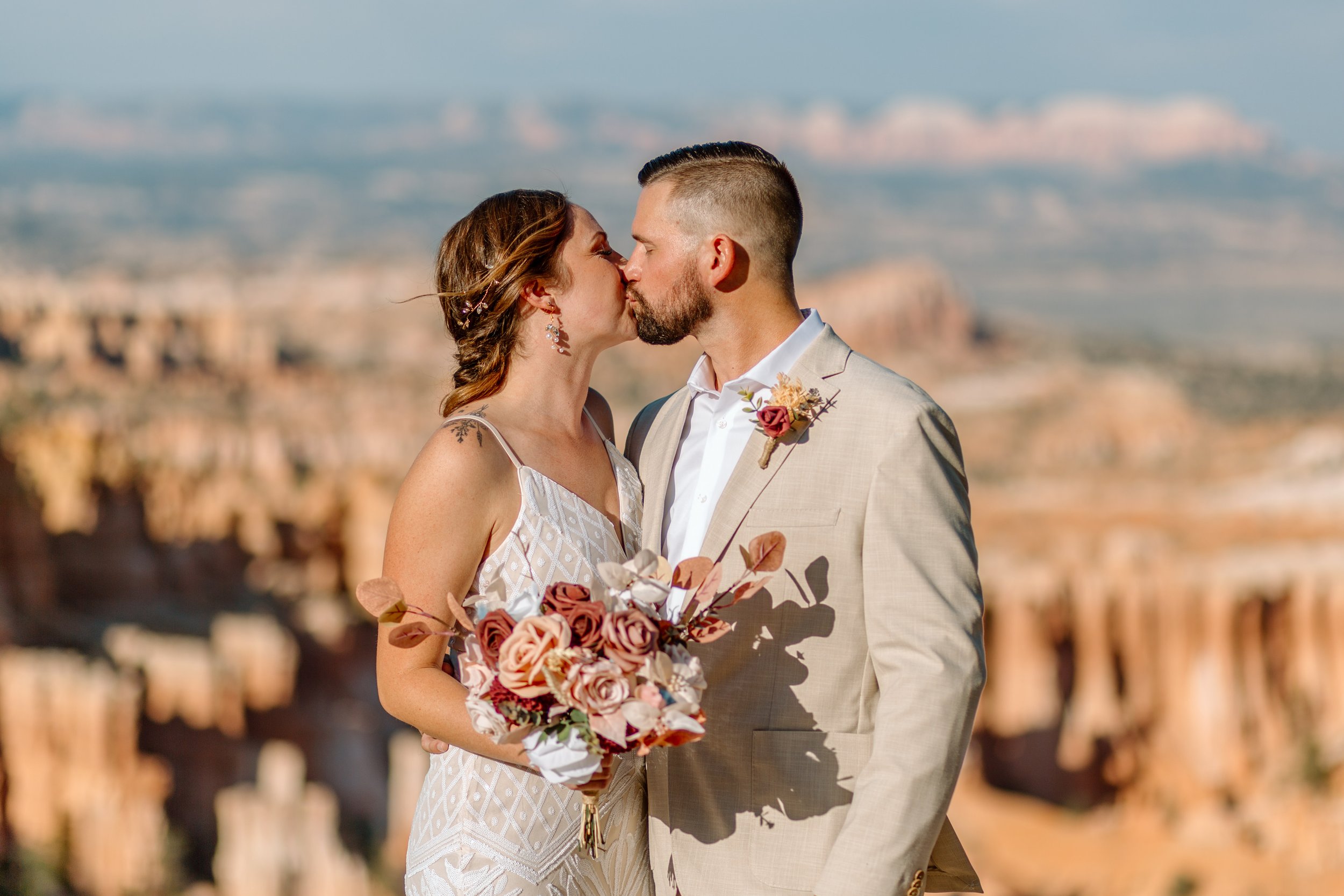  couple shares a kiss after their elopement ceremony in utah national park 