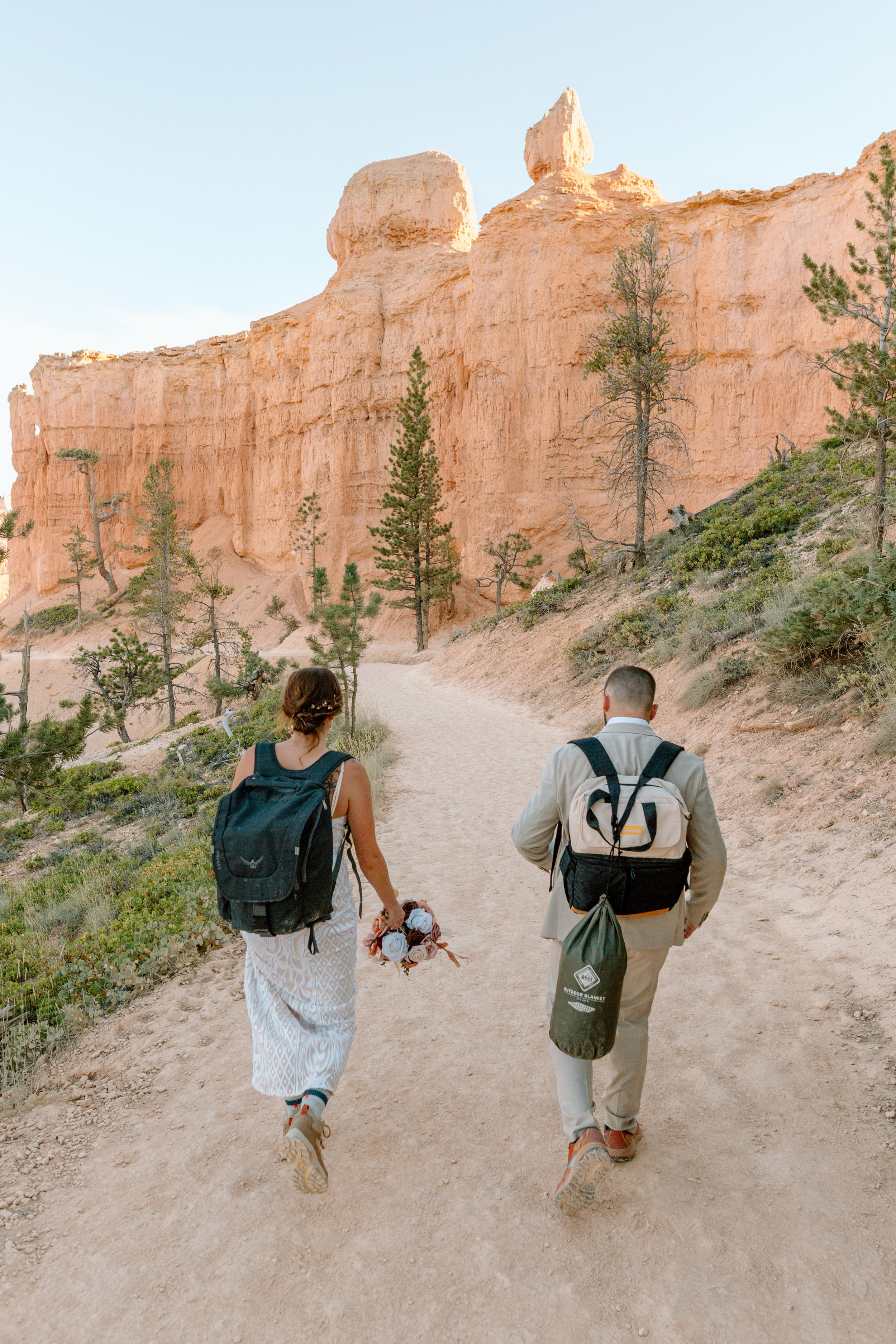  utah elopement couple wears backpacks and hikes in bryce canyon national park 