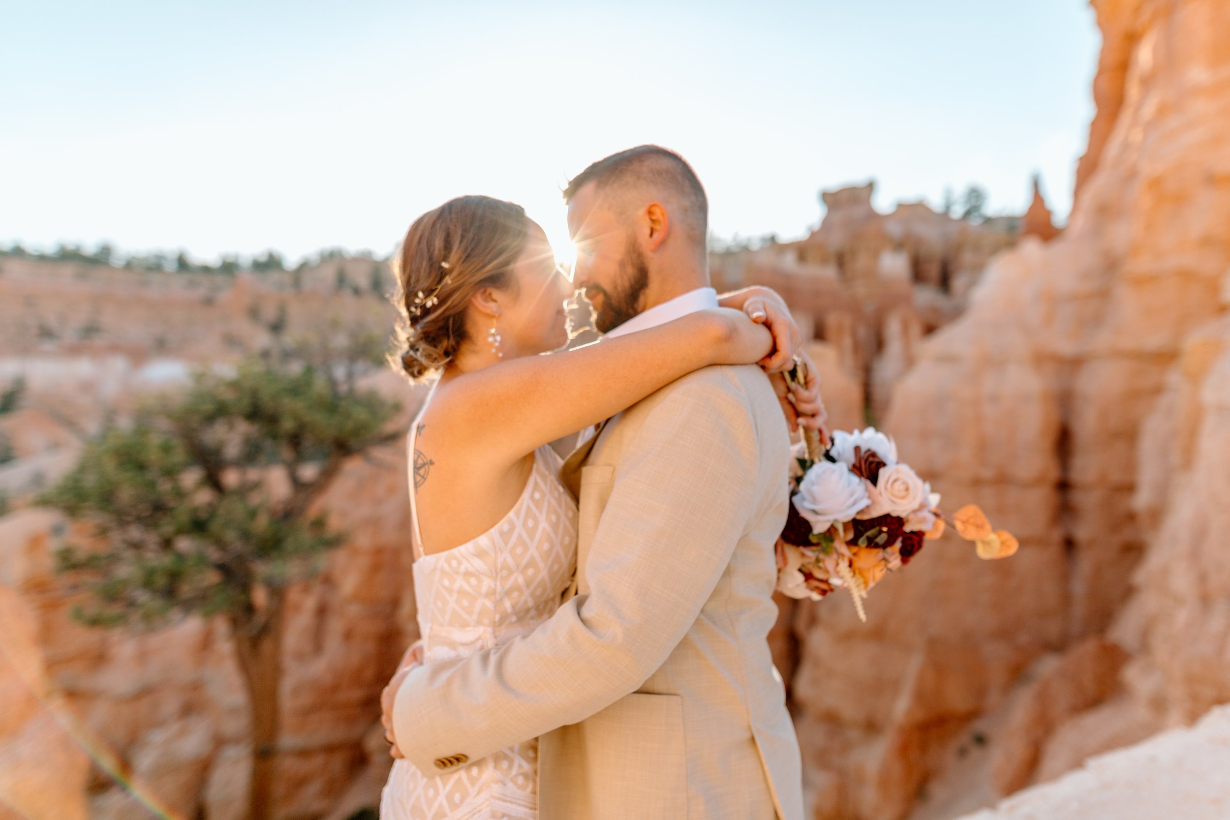  couple kisses as sun shines through by utah elopement photographer 
