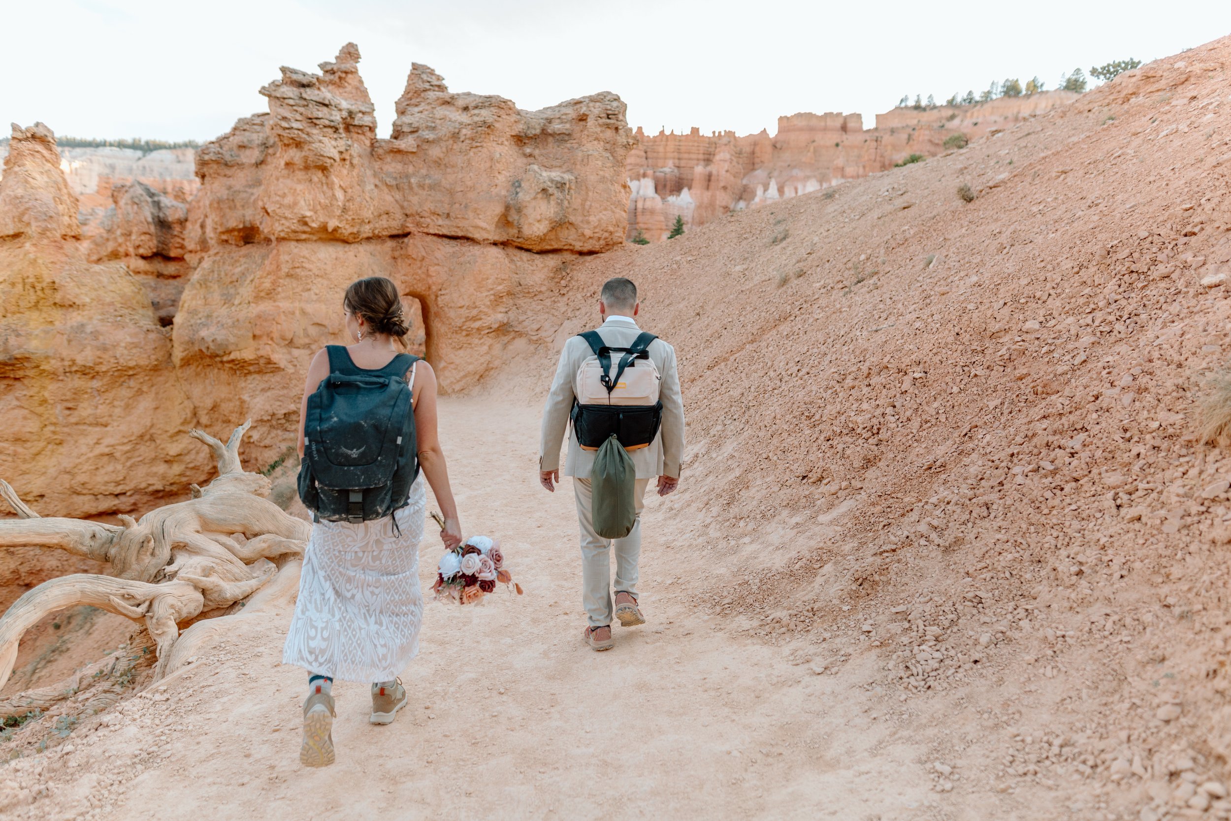  bryce canyon elopement couple hikes with backpacks by utah elopement photographer 