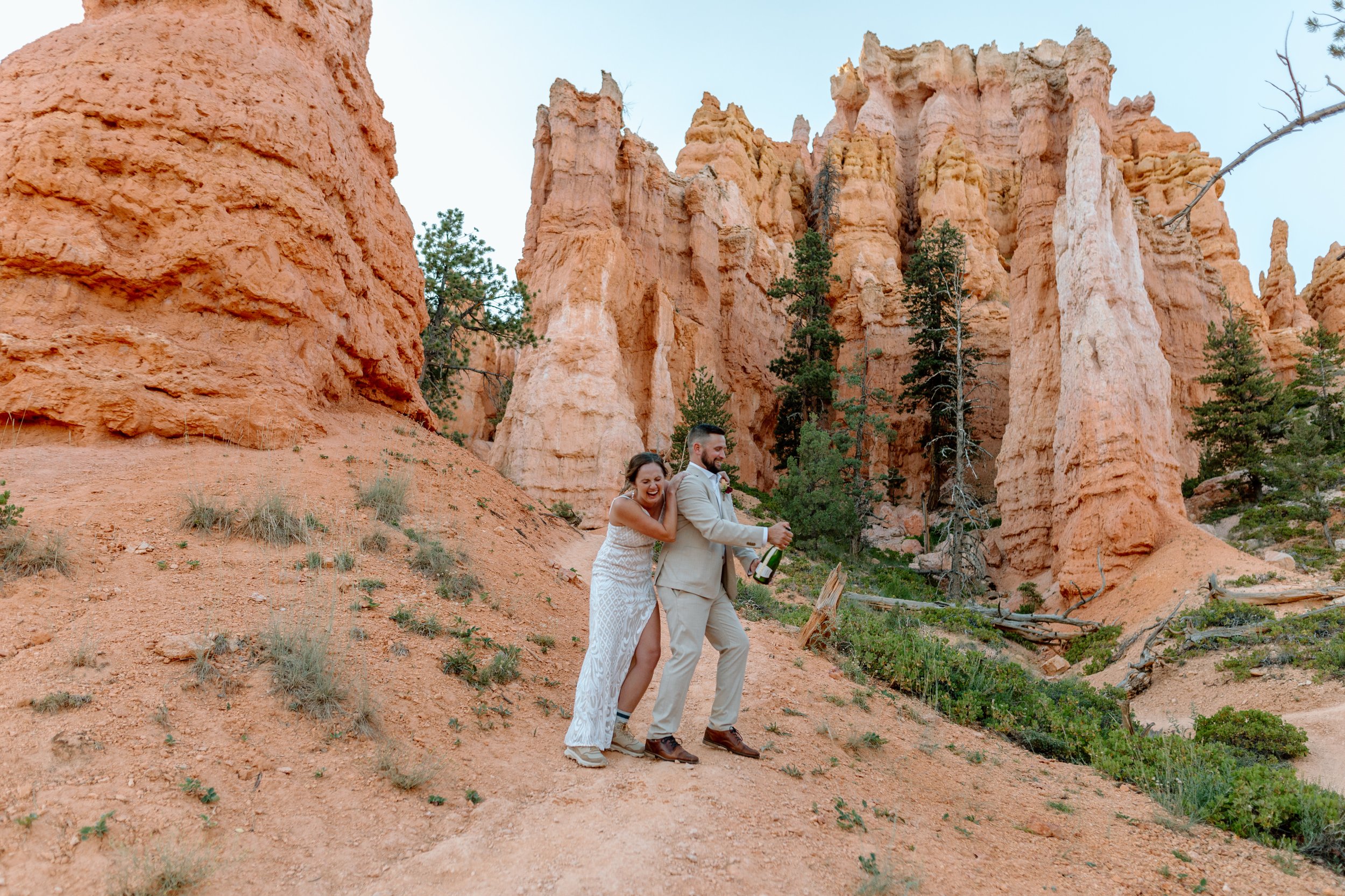  couple laughs after popping champagne during their bryce canyon national park elopement 