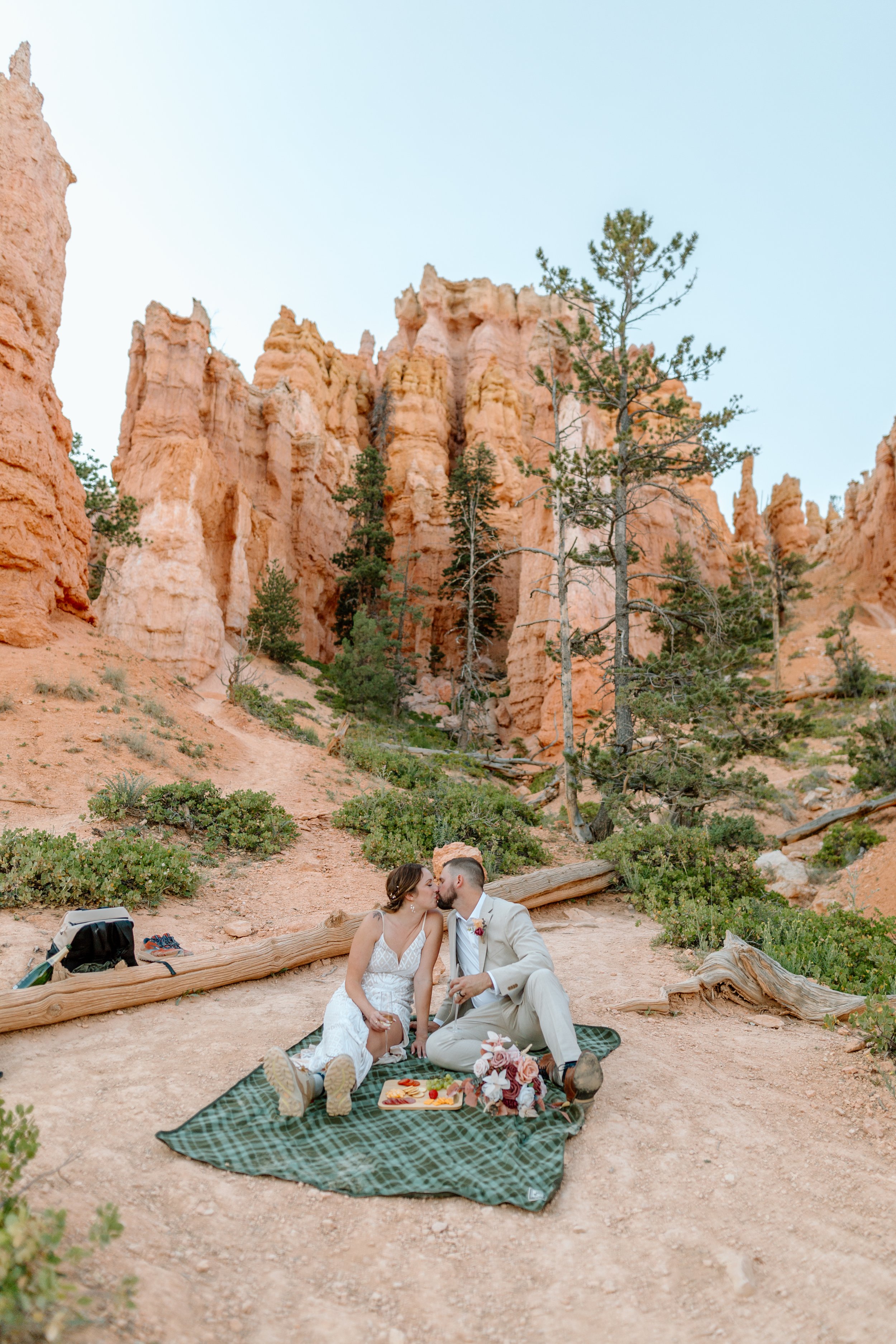  couple kisses on picnic blanket at bryce canyon by utah elopement photographer 