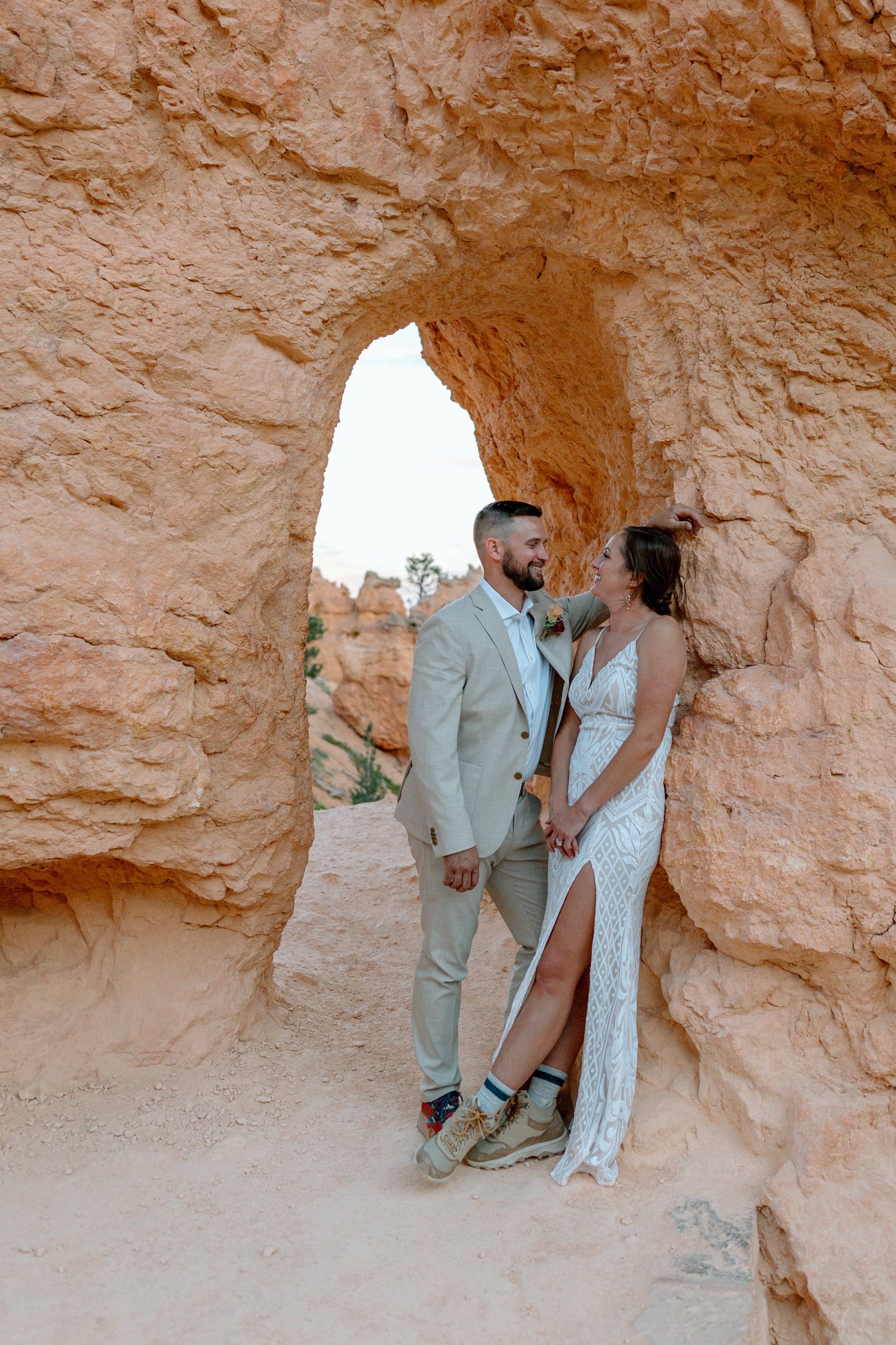  couple stands together in front of an arch at utah national park 