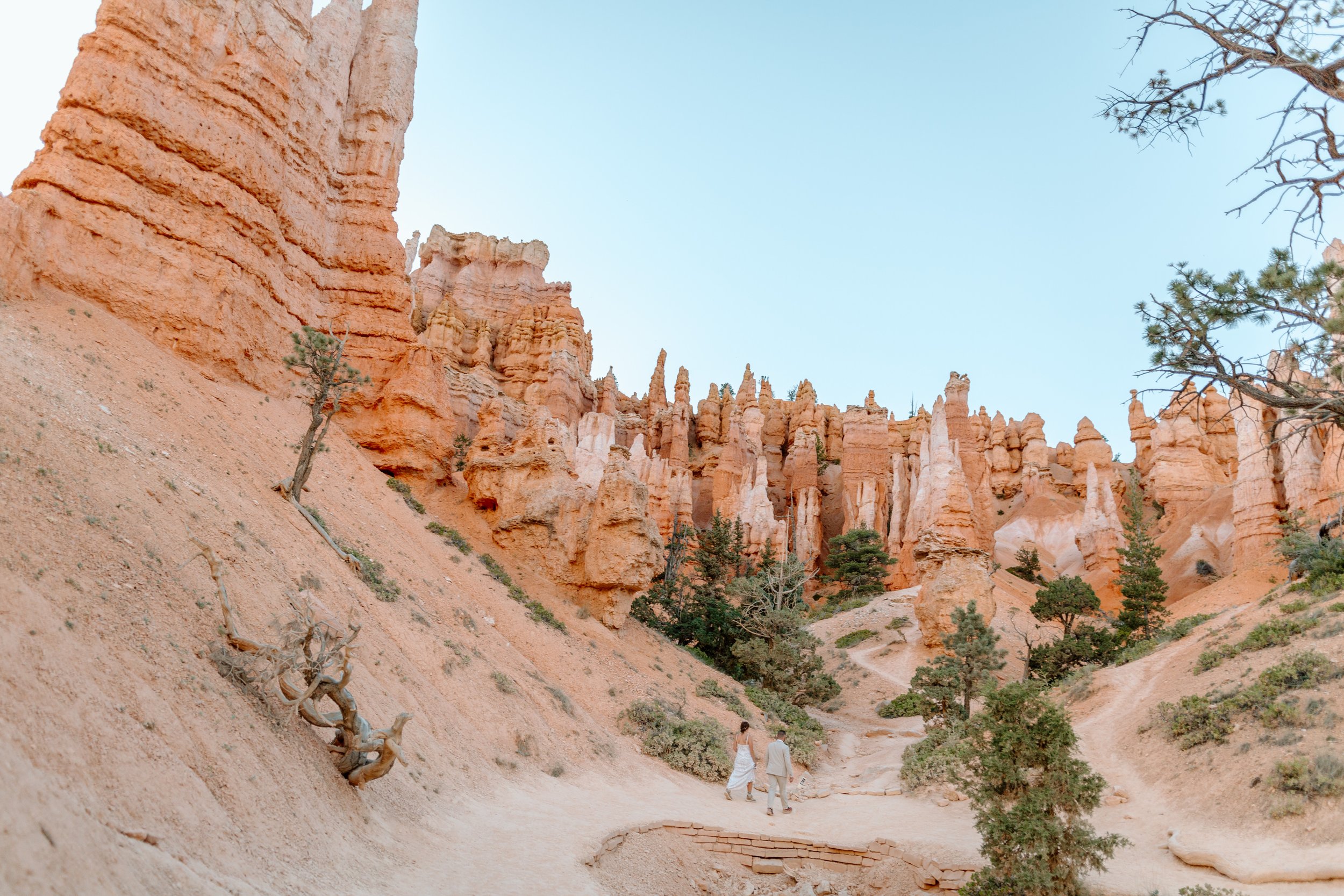 couple walks down trail among hoodoos during bryce canyon national park elopement 