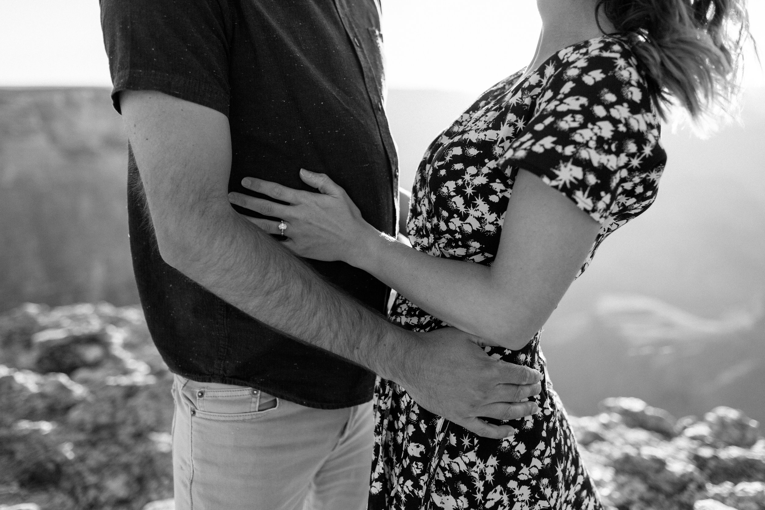  black and white closeup of a couple’s arms holding each other during their engagement session 