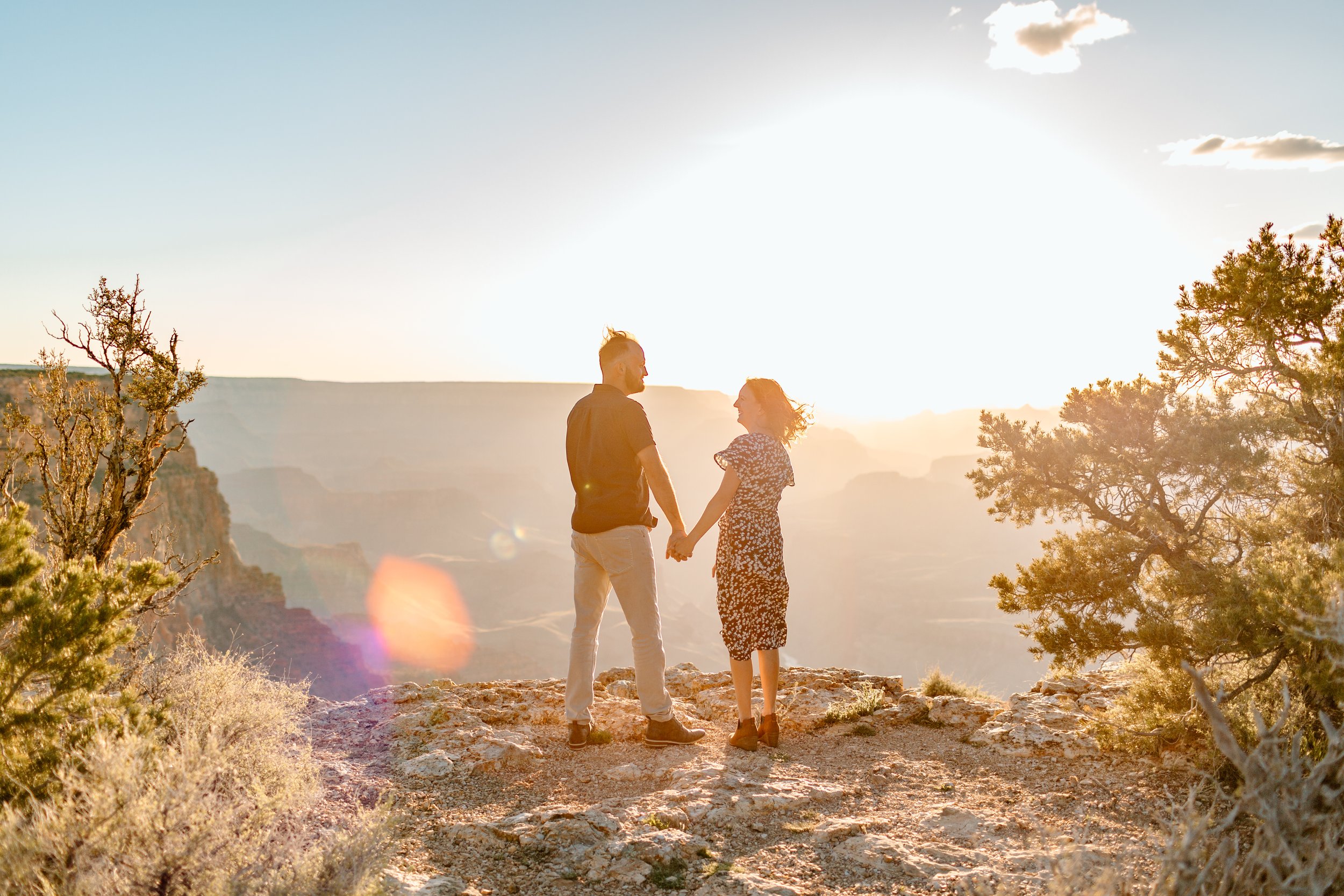  couple holds hands and stands on the grand canyon south rim 