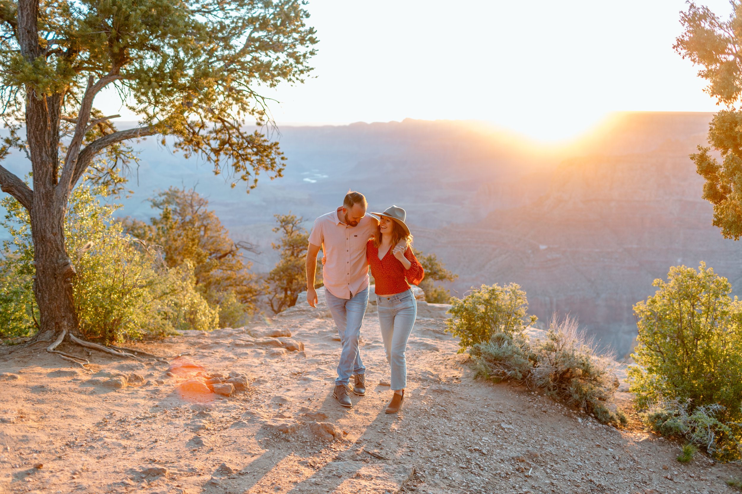  grand canyon engagement couple walks together up a hill during grand canyon engagement session 