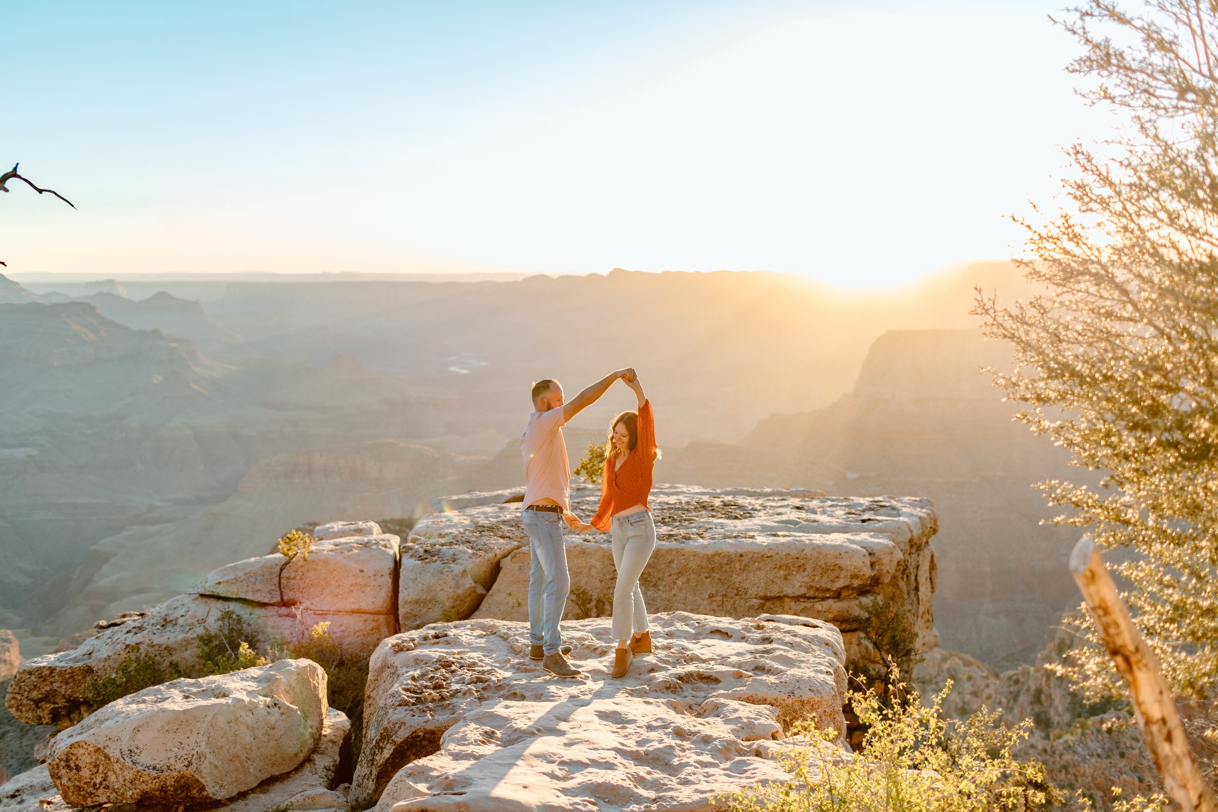  couple does a dance twirl in front of grand canyon sunrise for their arizona engagement session 