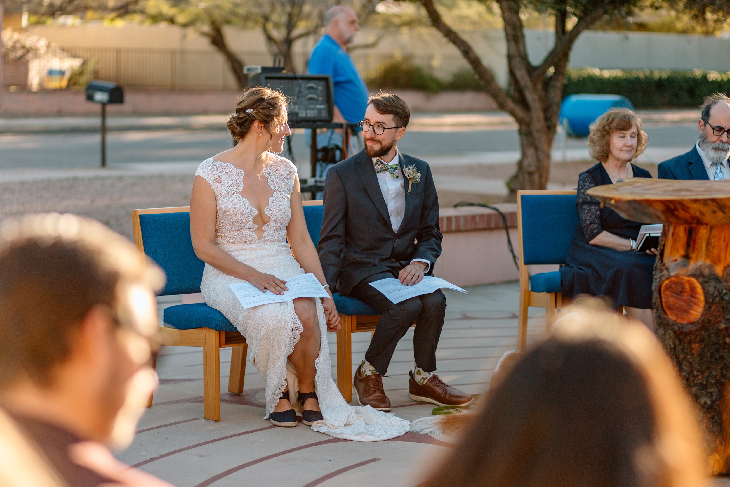  couple holds hands and looks lovingly at each other during their tucson wedding 