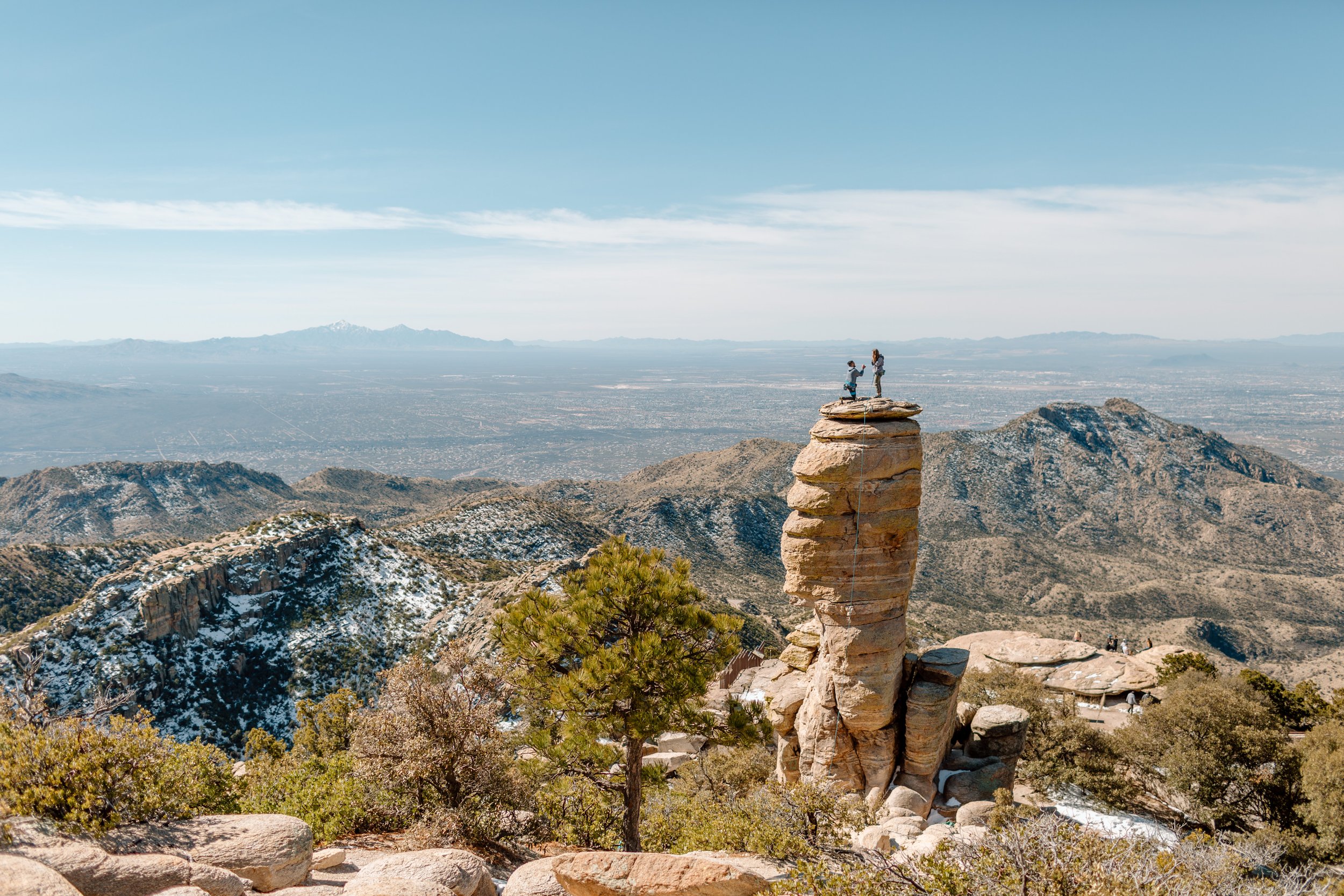  wide shot of a man proposing to his girlfriend on top of a hoodoo on mount lemmon arizona 