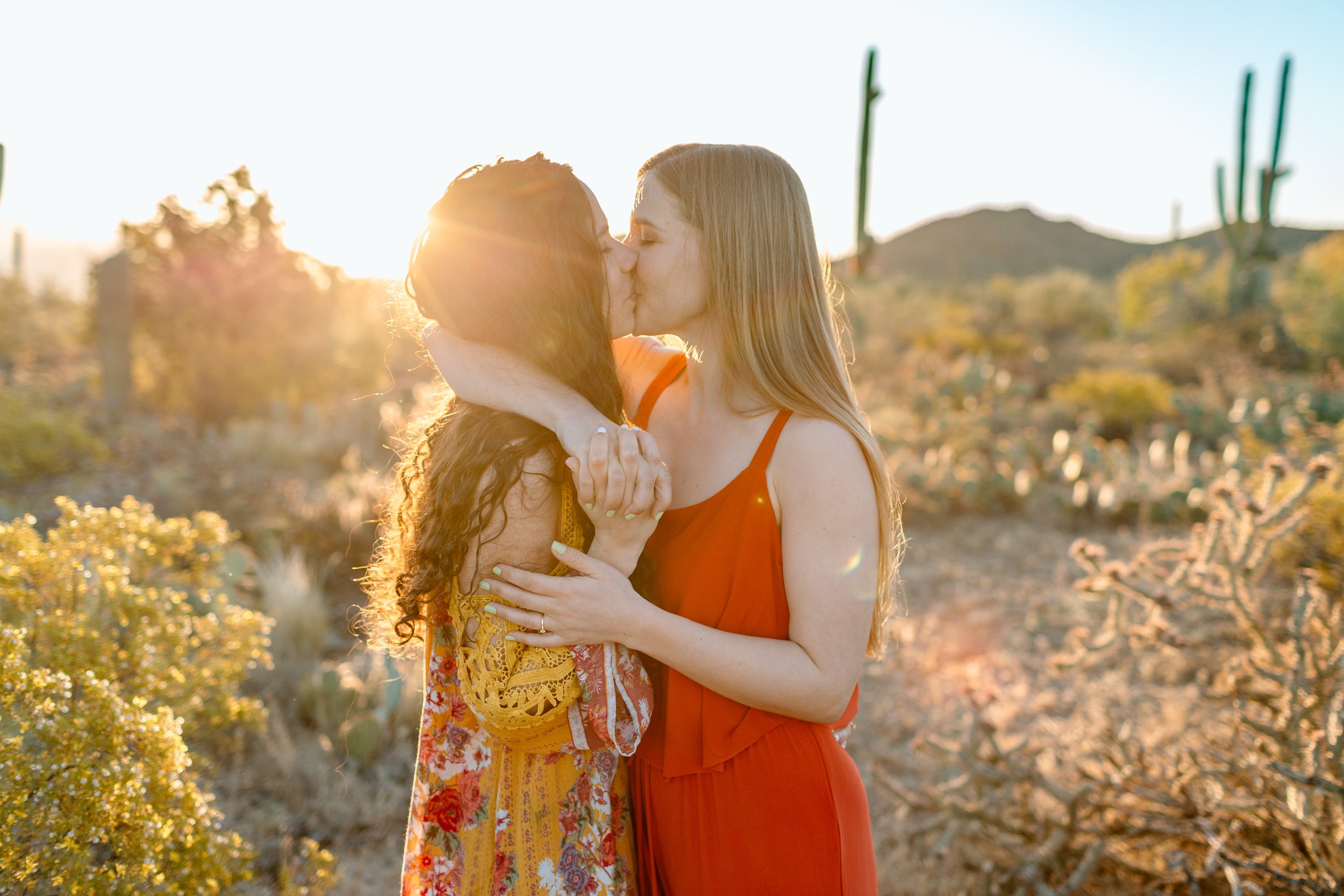  lesbian couple kisses at sunrise in the sonoran desert 