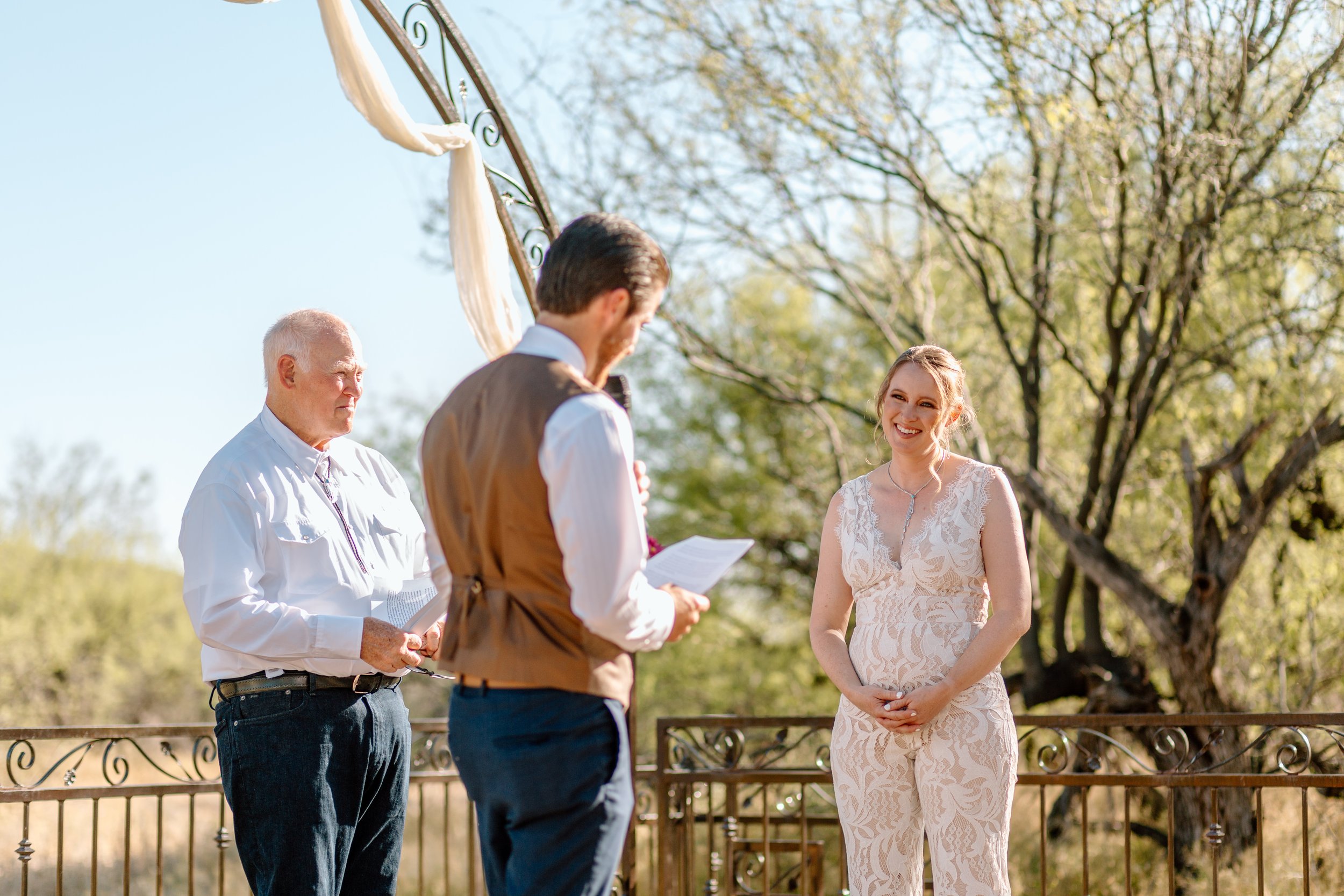  woman smiles at husband as he reads his vows during their arizona elopement 