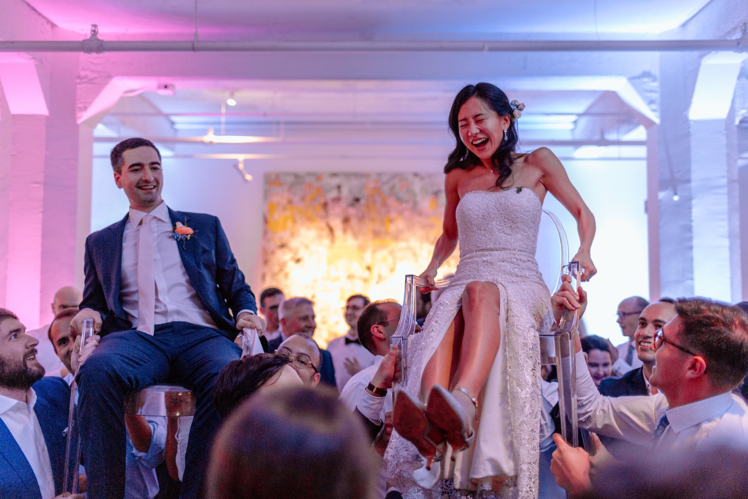  couple smiles and laughs while being lifted for their hora dance 