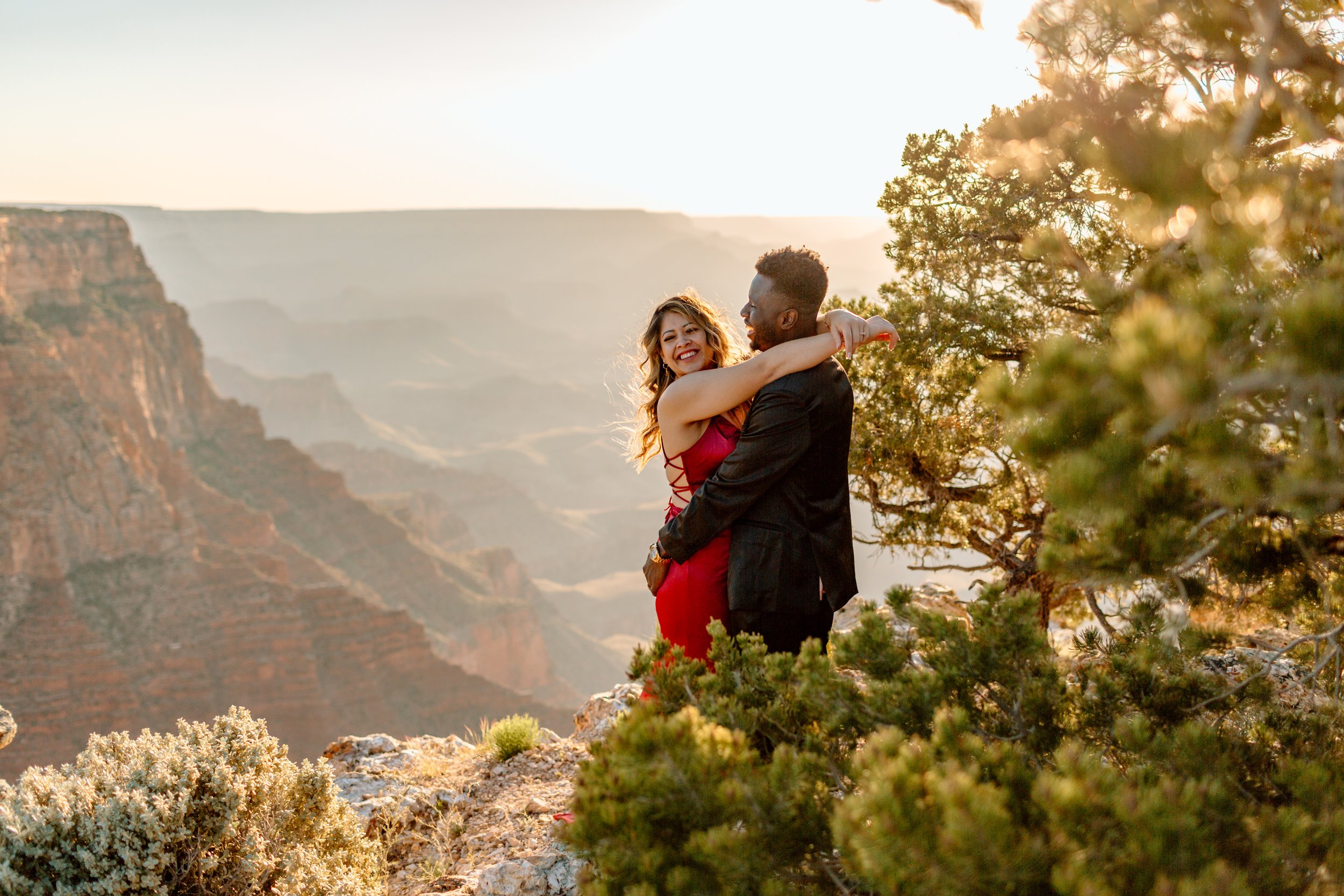  couple cuddles and laughs together during a grand canyon sunset 