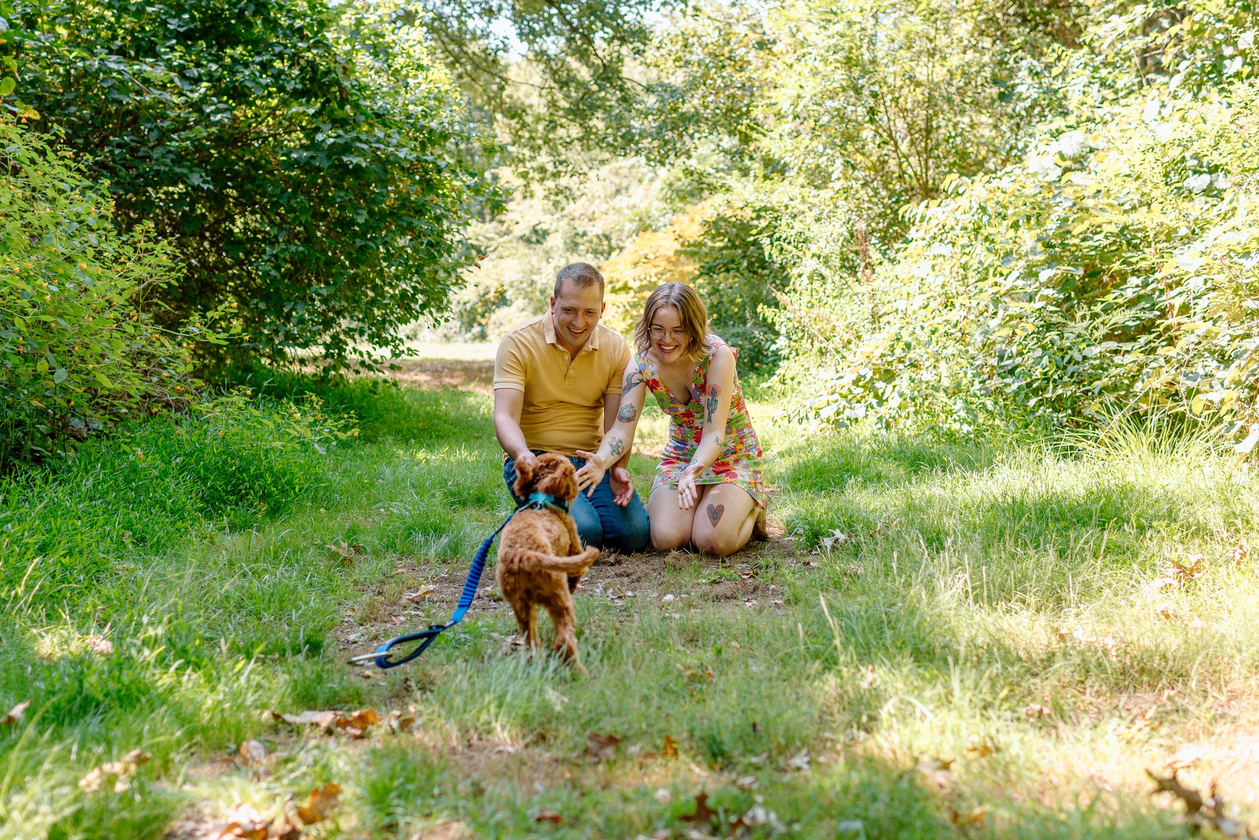  couple calls for their puppy as he runs toward them during their engagement session 