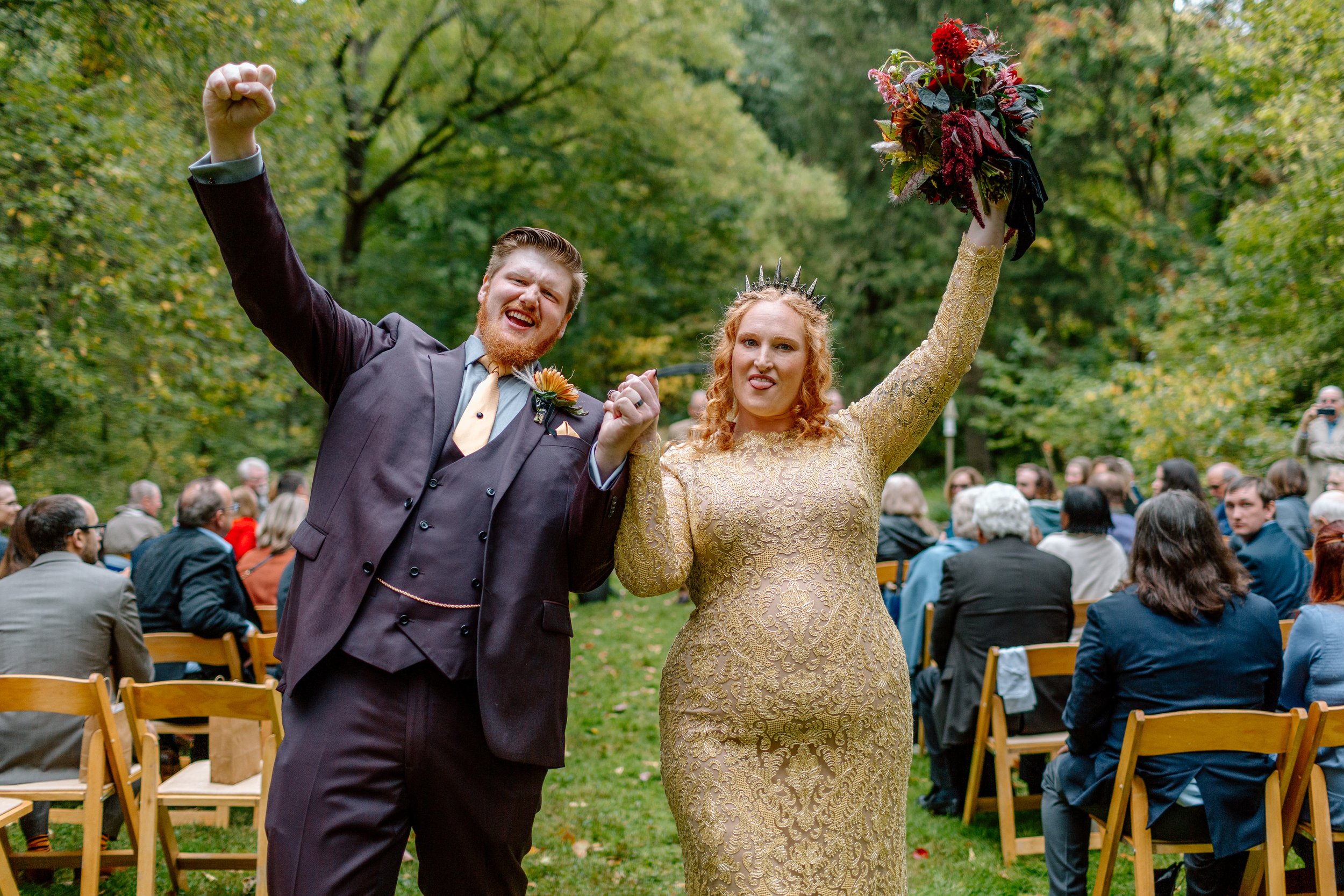  couple celebrates at the end of the aisle after their rainy wedding 