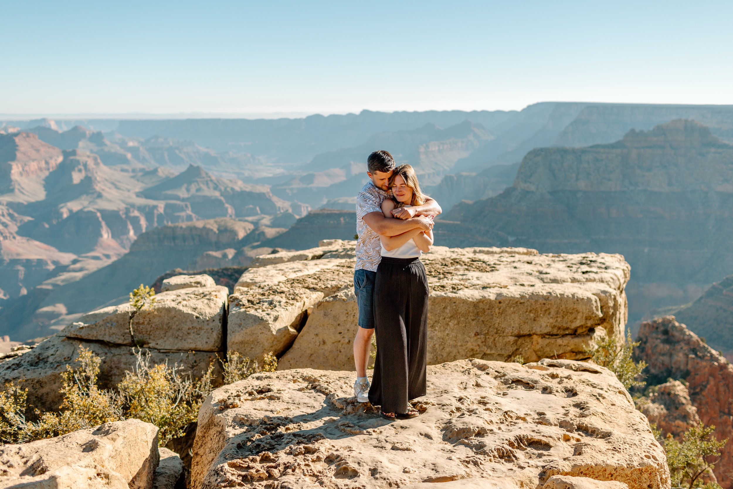  couple holds each other after their grand canyon proposal 