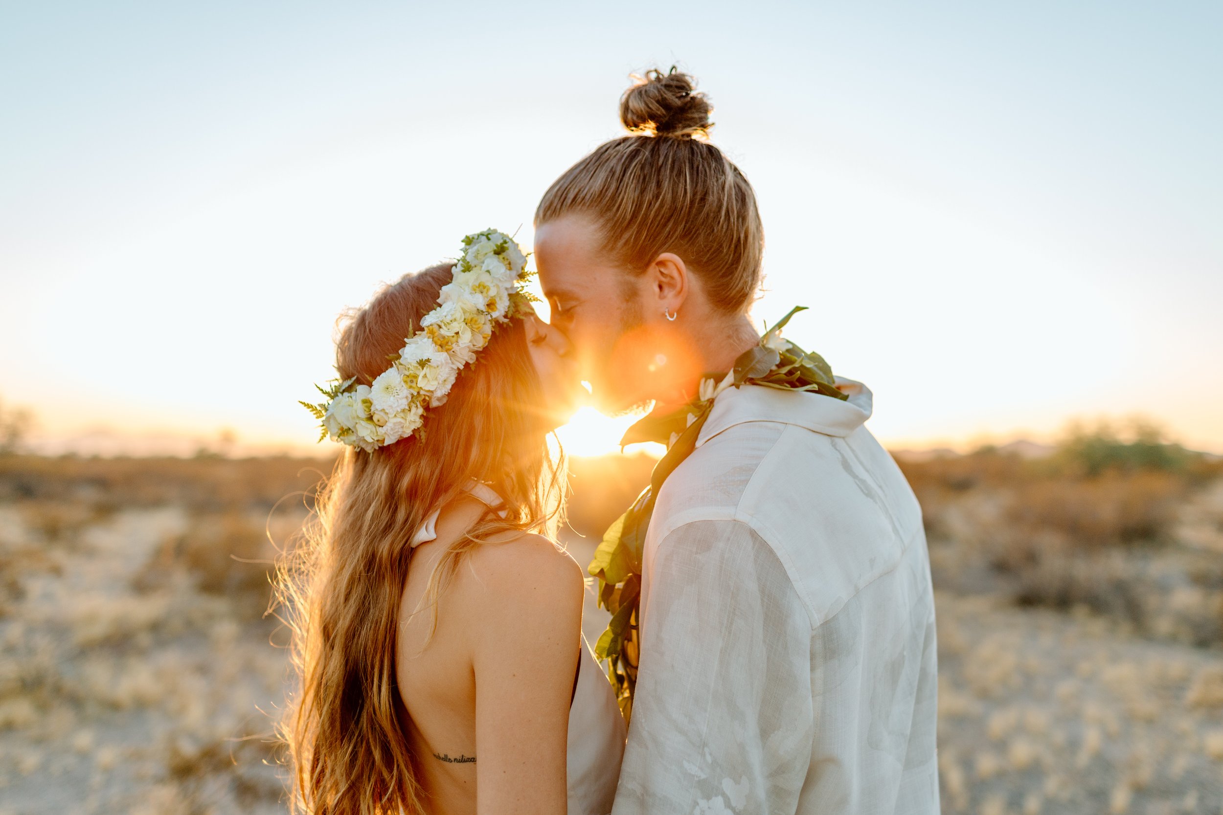  couple touches their noses together as the sunset shines through at their arizona elopement 