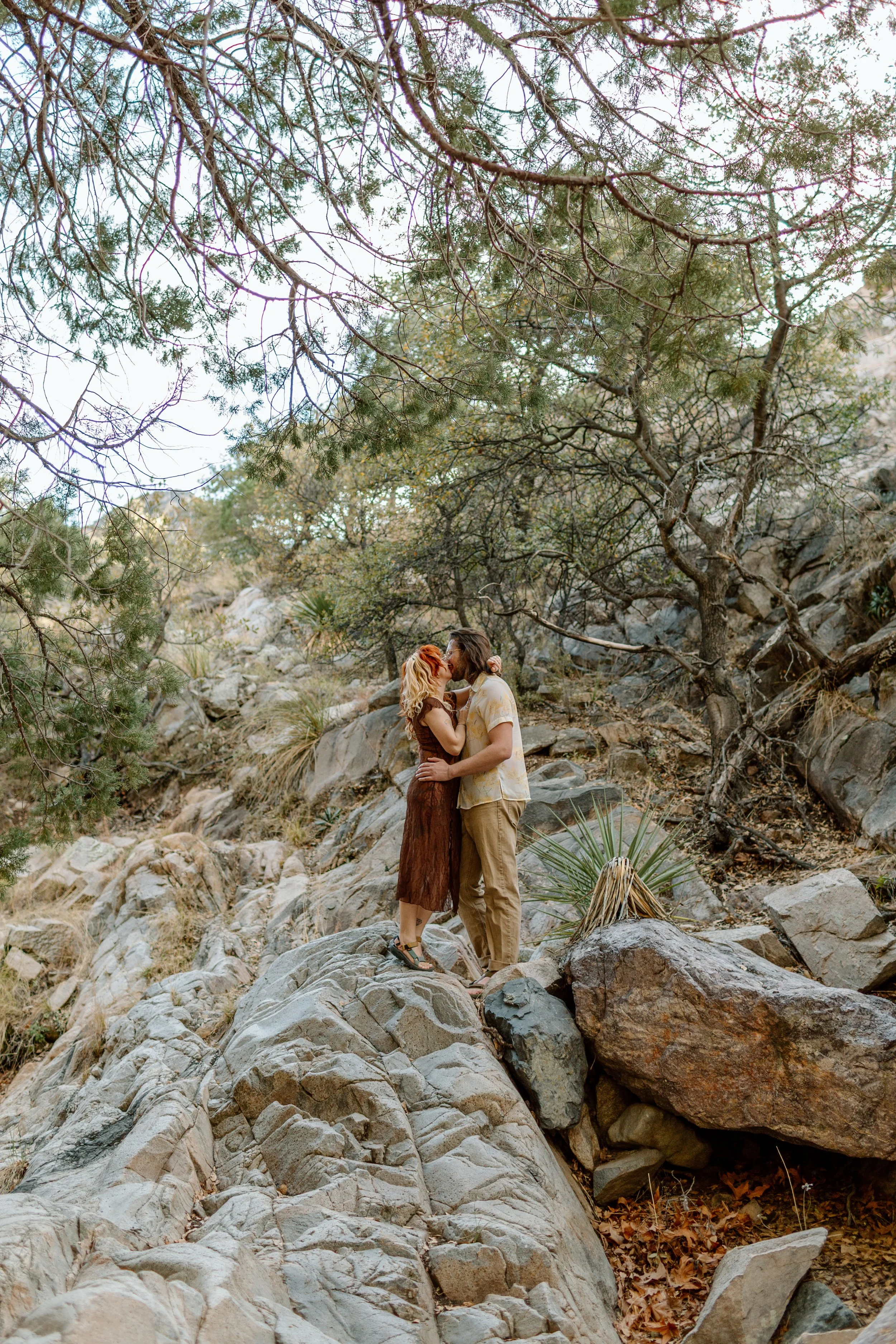  couple kisses while standing on rocks at Madera Canyon 