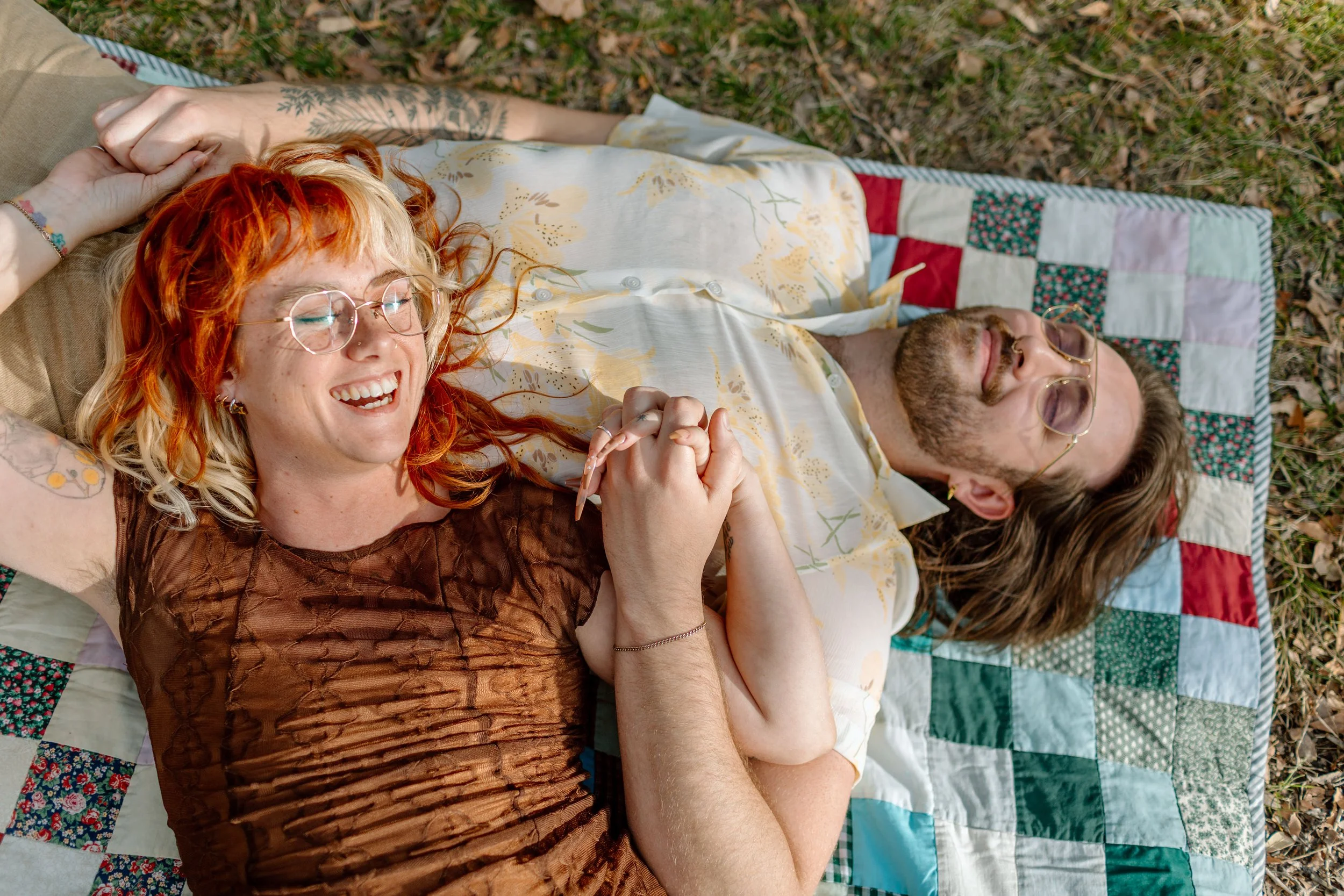  couple snuggles and laughs together on picnic blanket by Tucson engagement photographer 