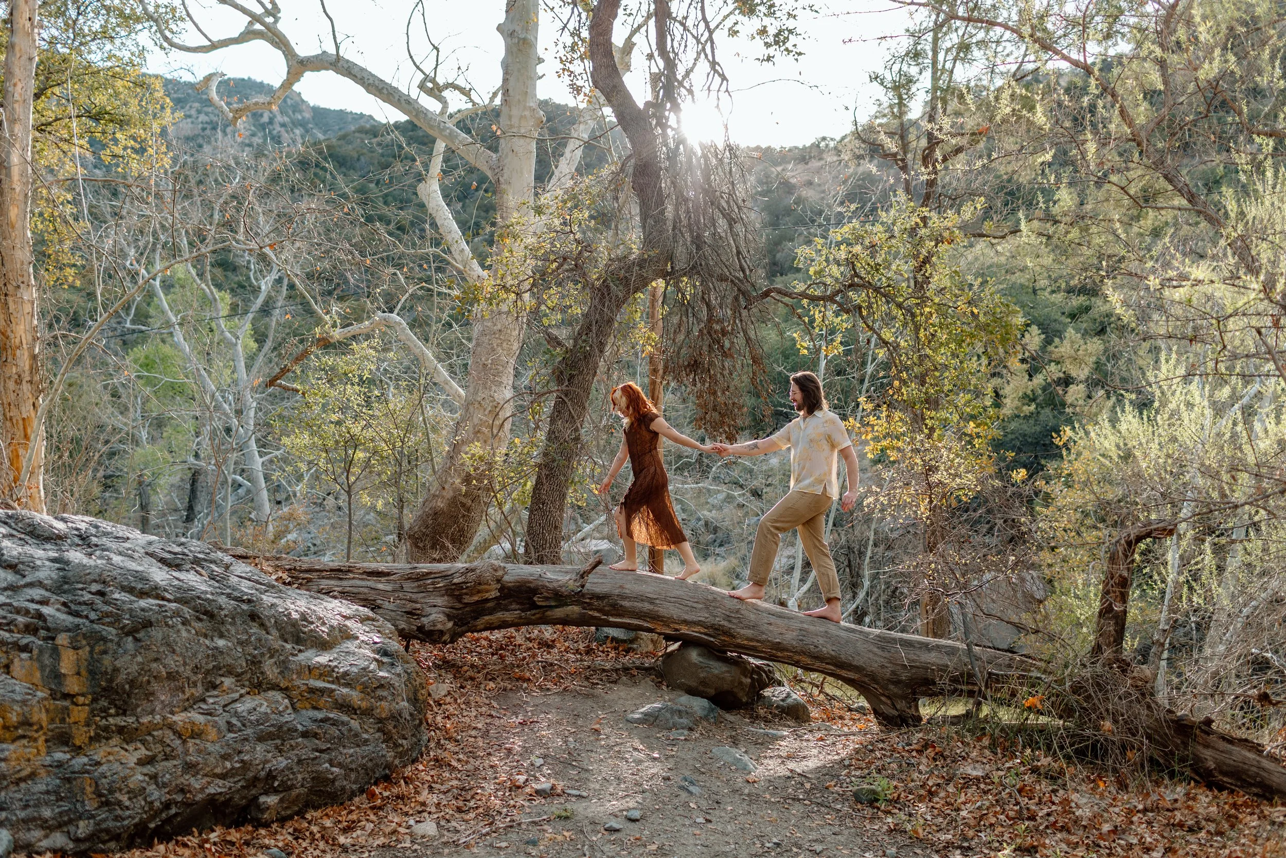  couple walks across a fallen log together for Tucson engagement session 