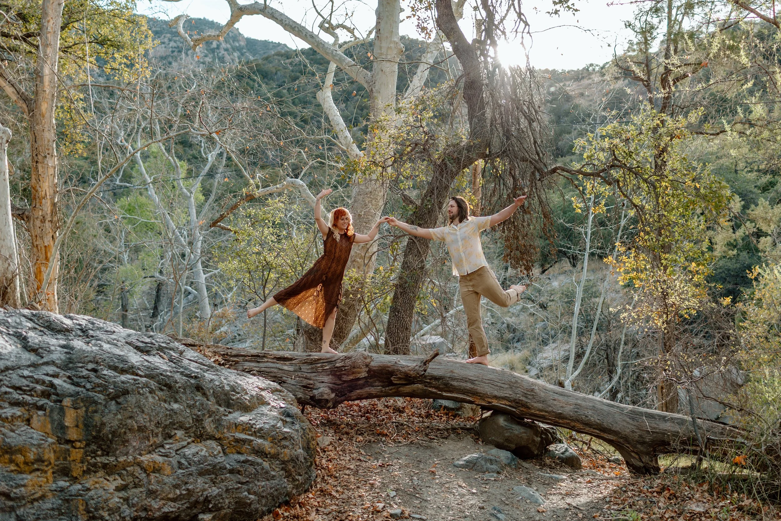  couple make a silly pose while standing on fallen tree for Madera Canyon engagement session 