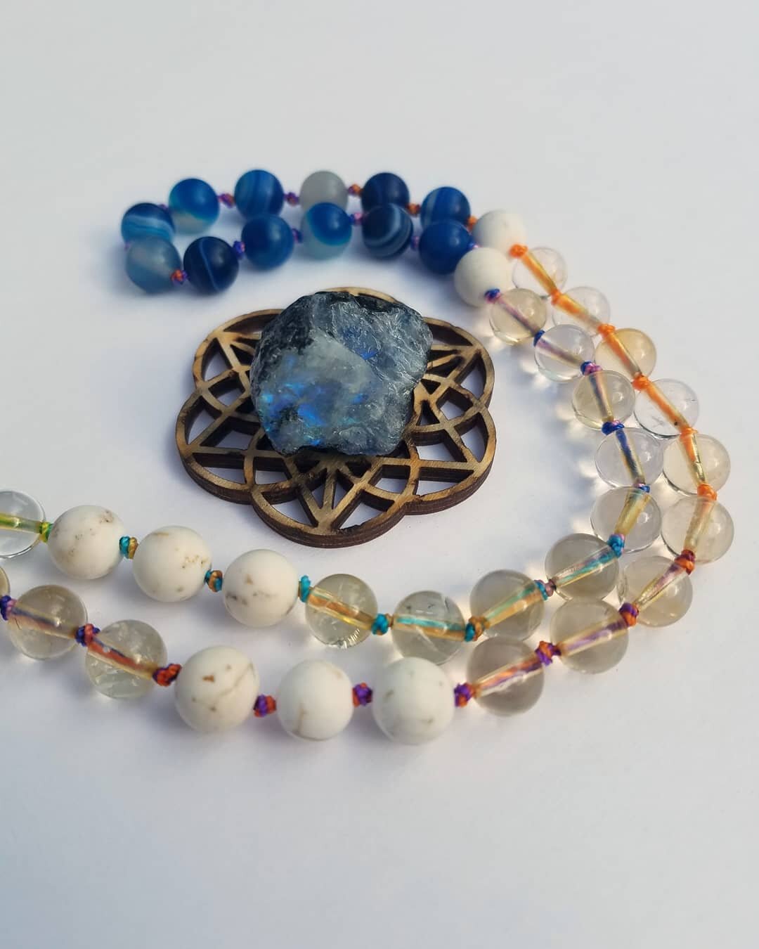 This is the Rainbow Skies mala. It features Clear Quartz, Blue Agate and White Turquoise. This blend of stones speaks to the upper chakras, aligning you with truth, communication, clear spiritual connection and guidance toward your intended purpose. 