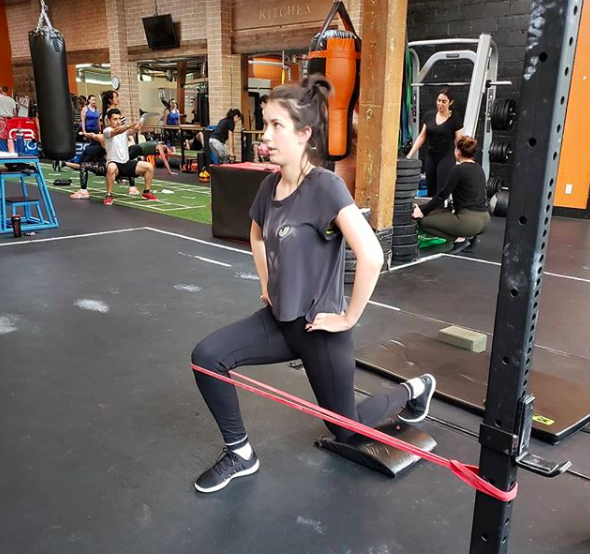 Using a resistance band to drive external rotation at the hip during a split squat