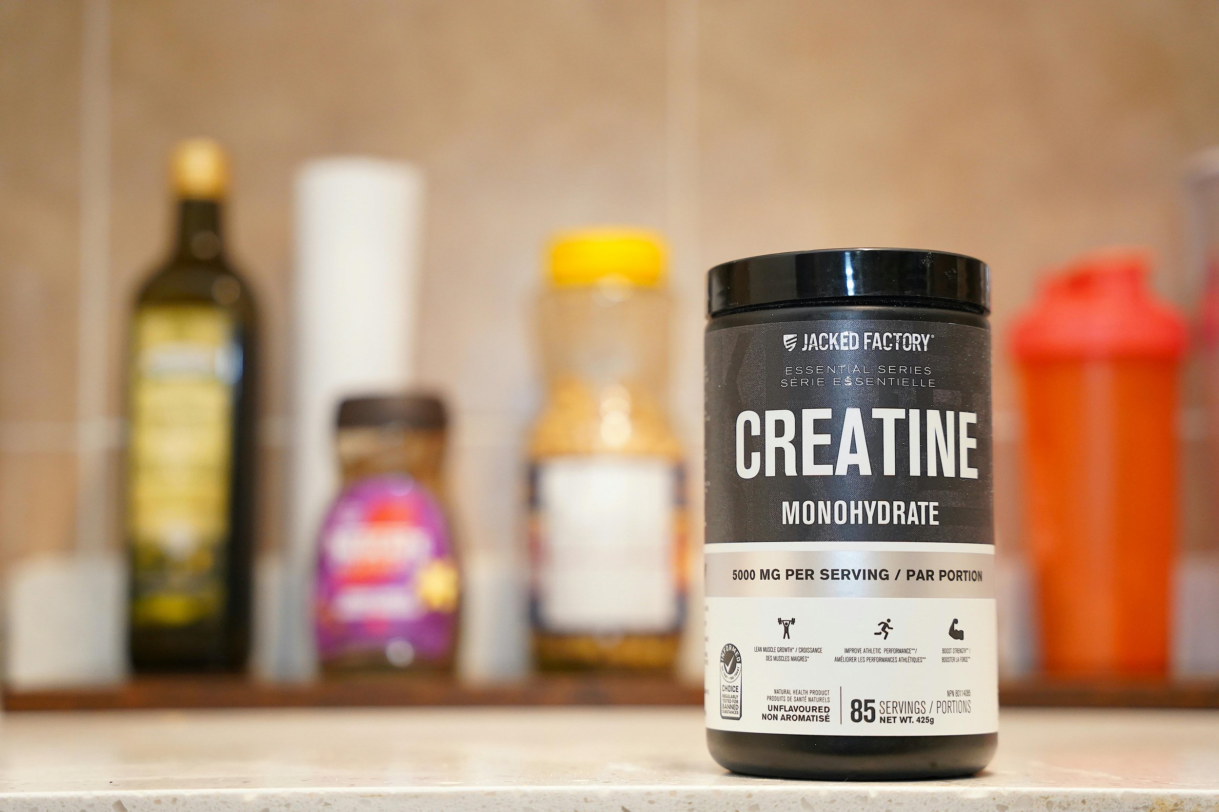 Container of creatine supplement powder used by athletes for strength and recovery