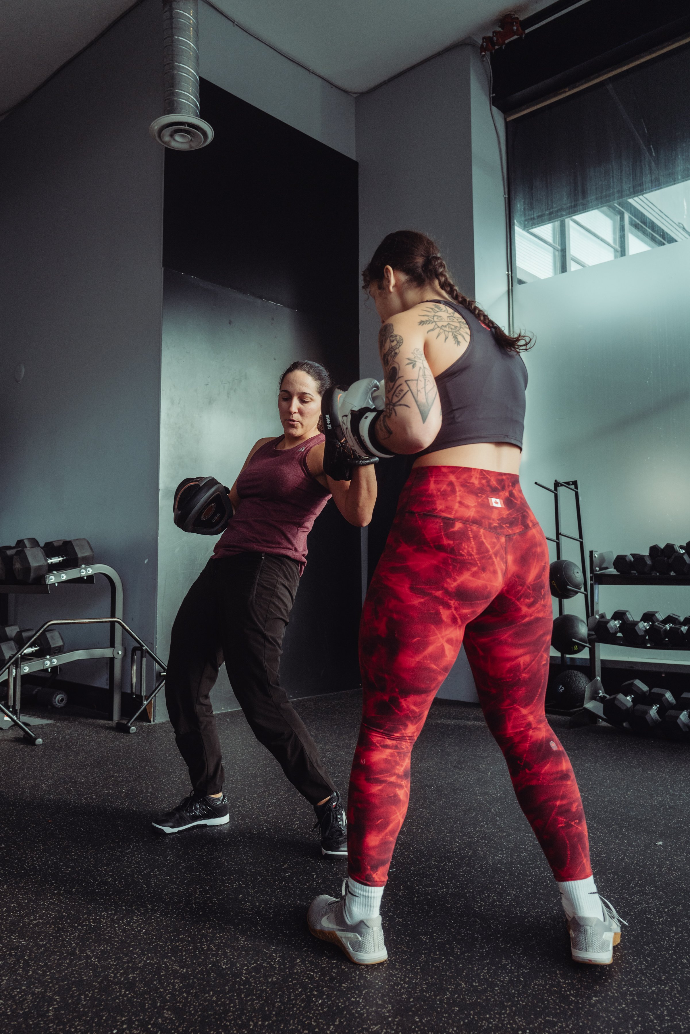oxing coach teaching proper uppercut technique to a client in Vancouver