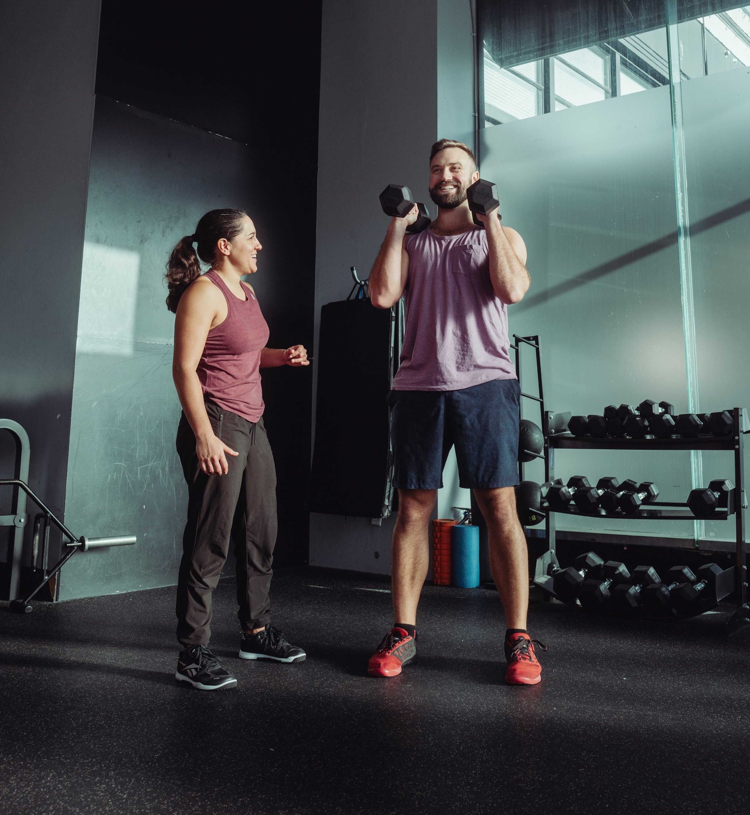 Coach smiling with a client during a private training session at Avos Strength