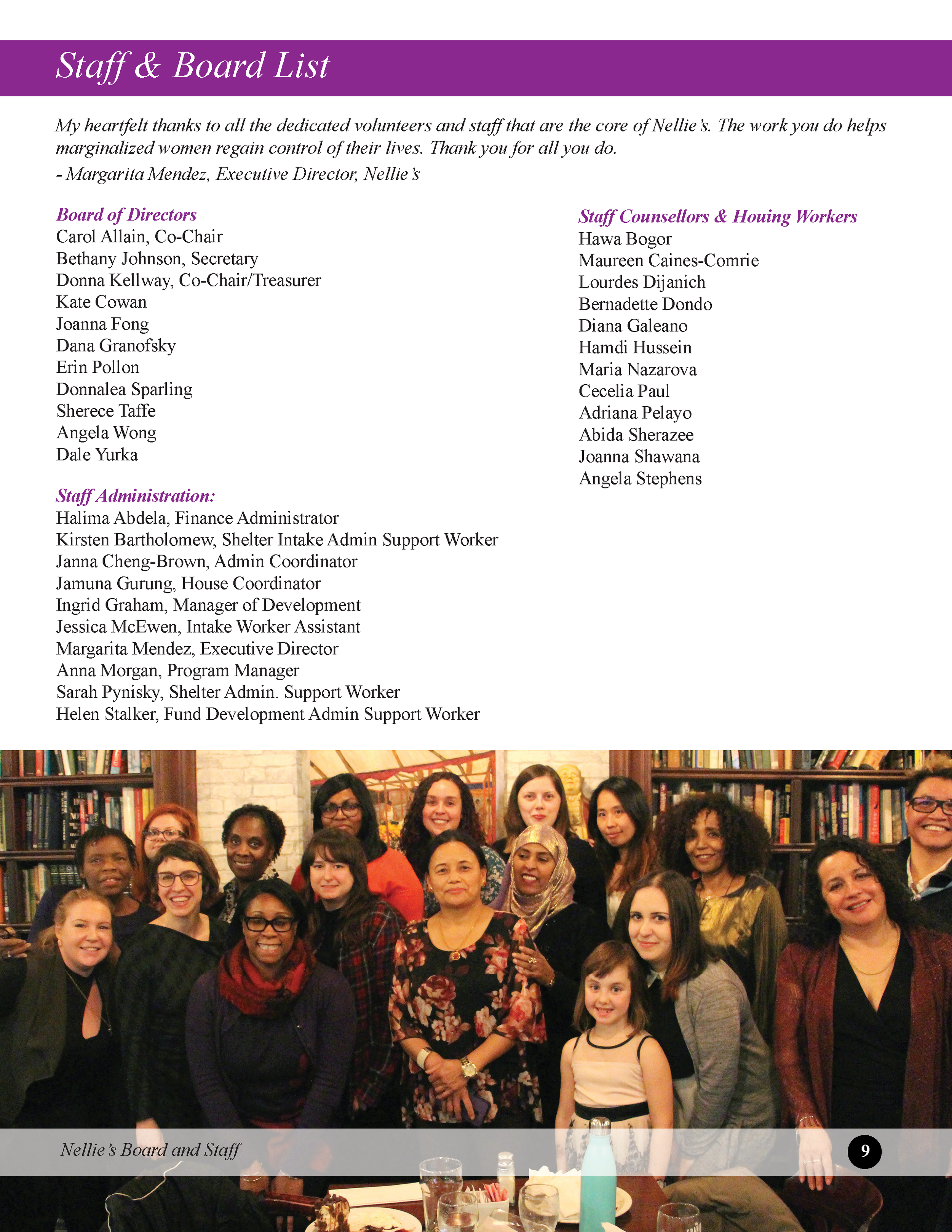 Group of diverse women and girls gathered around a table with food and drinks, smiling for a photo in a room with bookshelves.