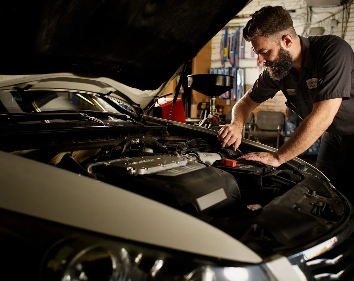 Photo of a man working on a car engine