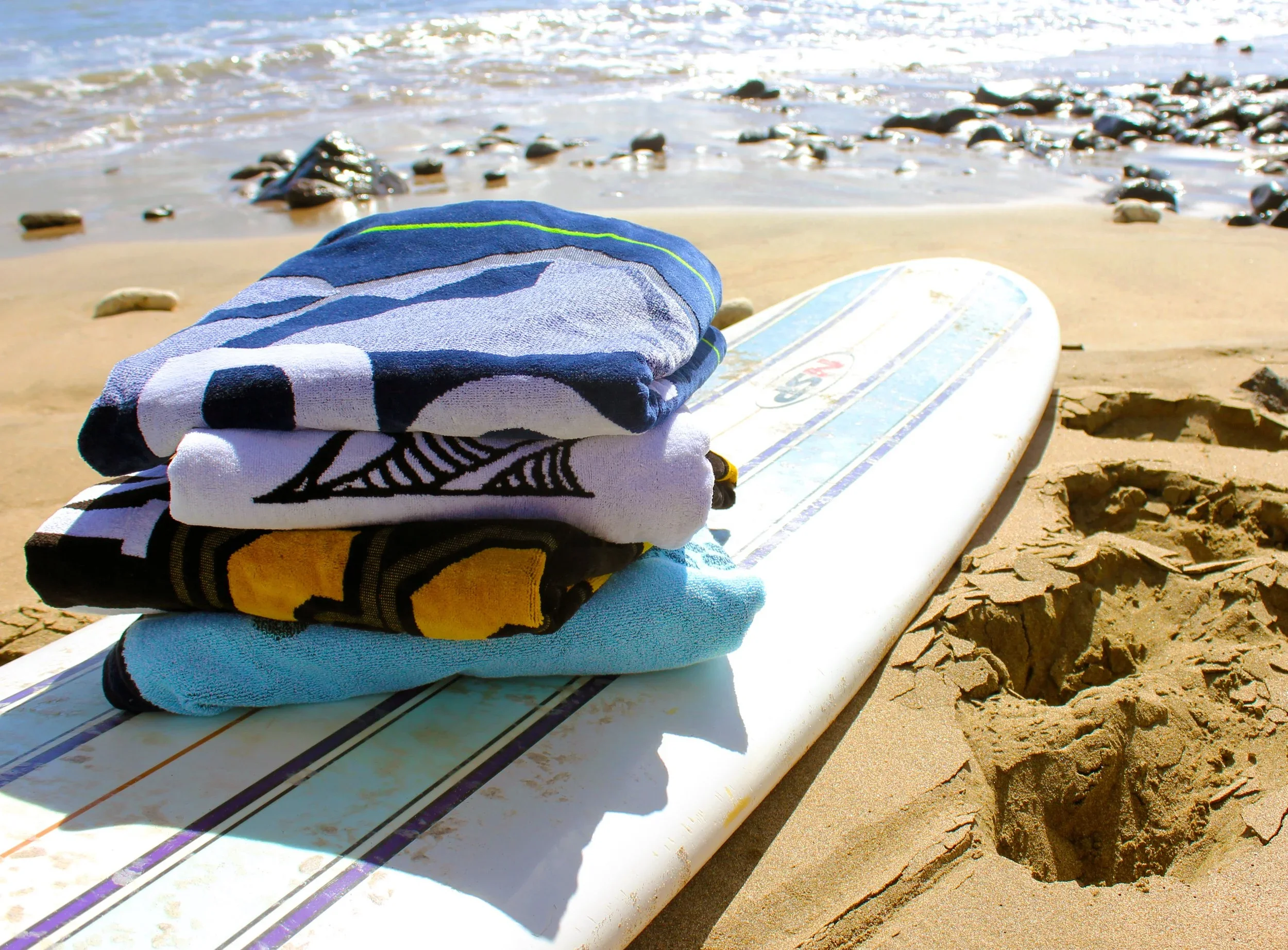 Several colorful, patterned beach towels