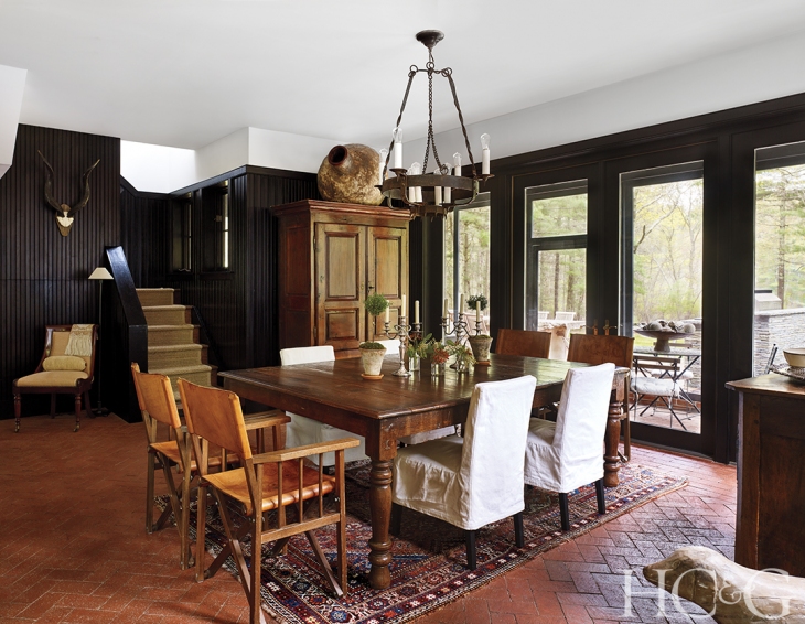  In the dining room, Kenyan leather safari chairs and slipcovered seating from  RH  surround a table fashioned from an Indian bed. 