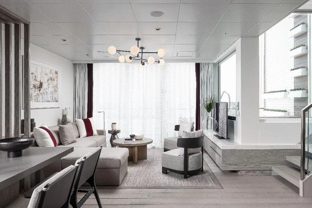 Luxurious Edge Villa on Celebrity Cruises showing seating and dining area with floor to ceiling sliding door