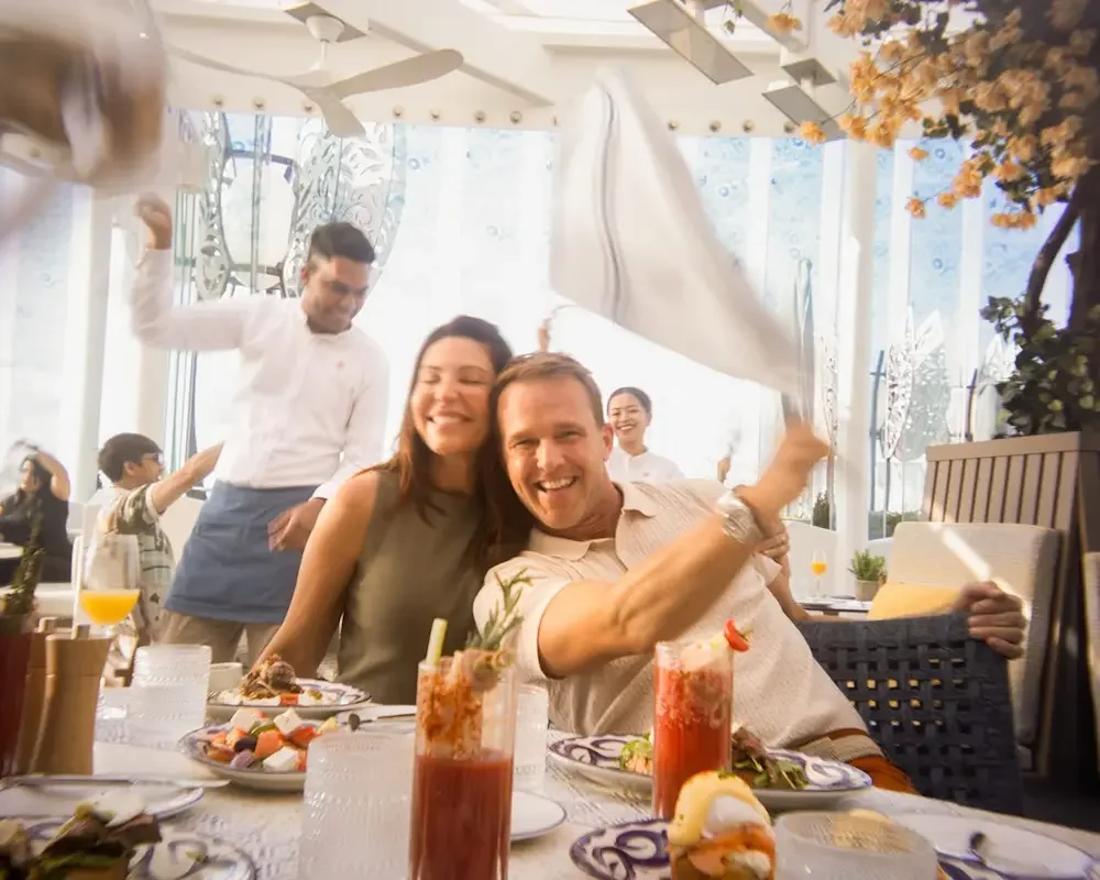 Bora Bora Restaurant coming to Celebrity Beyond after refresh. Image of a couple dining with plates of food