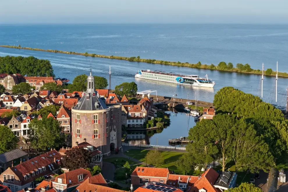 Viva river cruise ship on river in foreground with terracotta roofed buildings in foregroun